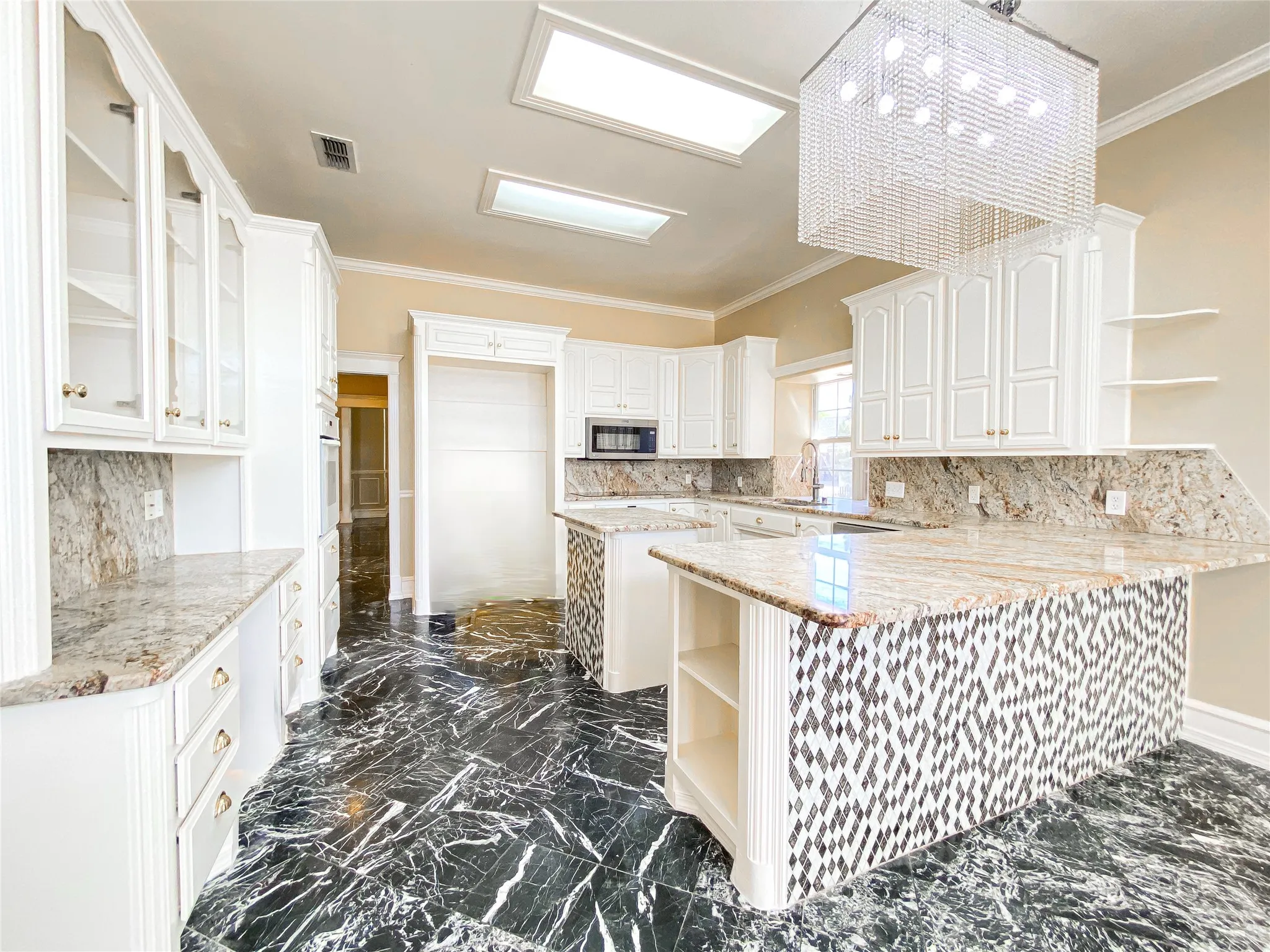 Kitchen with open shelves, a peninsula, crown molding, white cabinetry, and light stone countertops