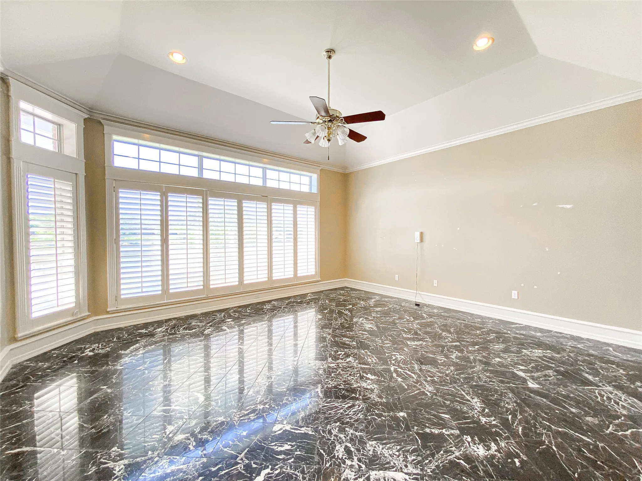 PRIMARY BEDROOM with recessed lighting, a ceiling fan, dark marble finish floors, and crown molding