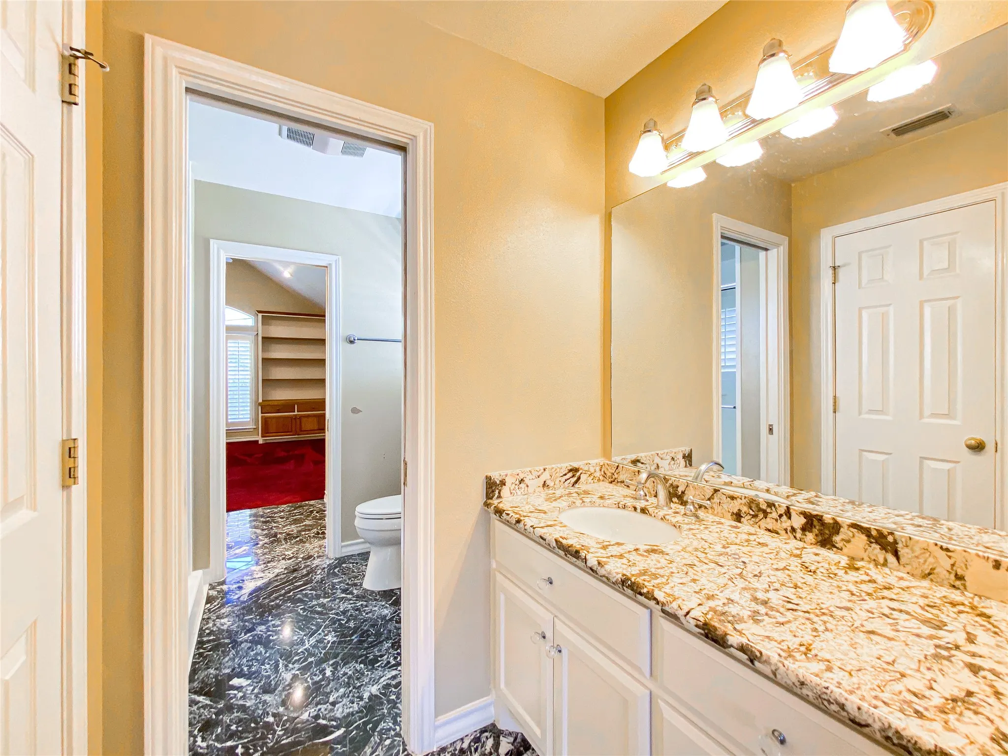 Bathroom with vanity and dark marble finish flooring
