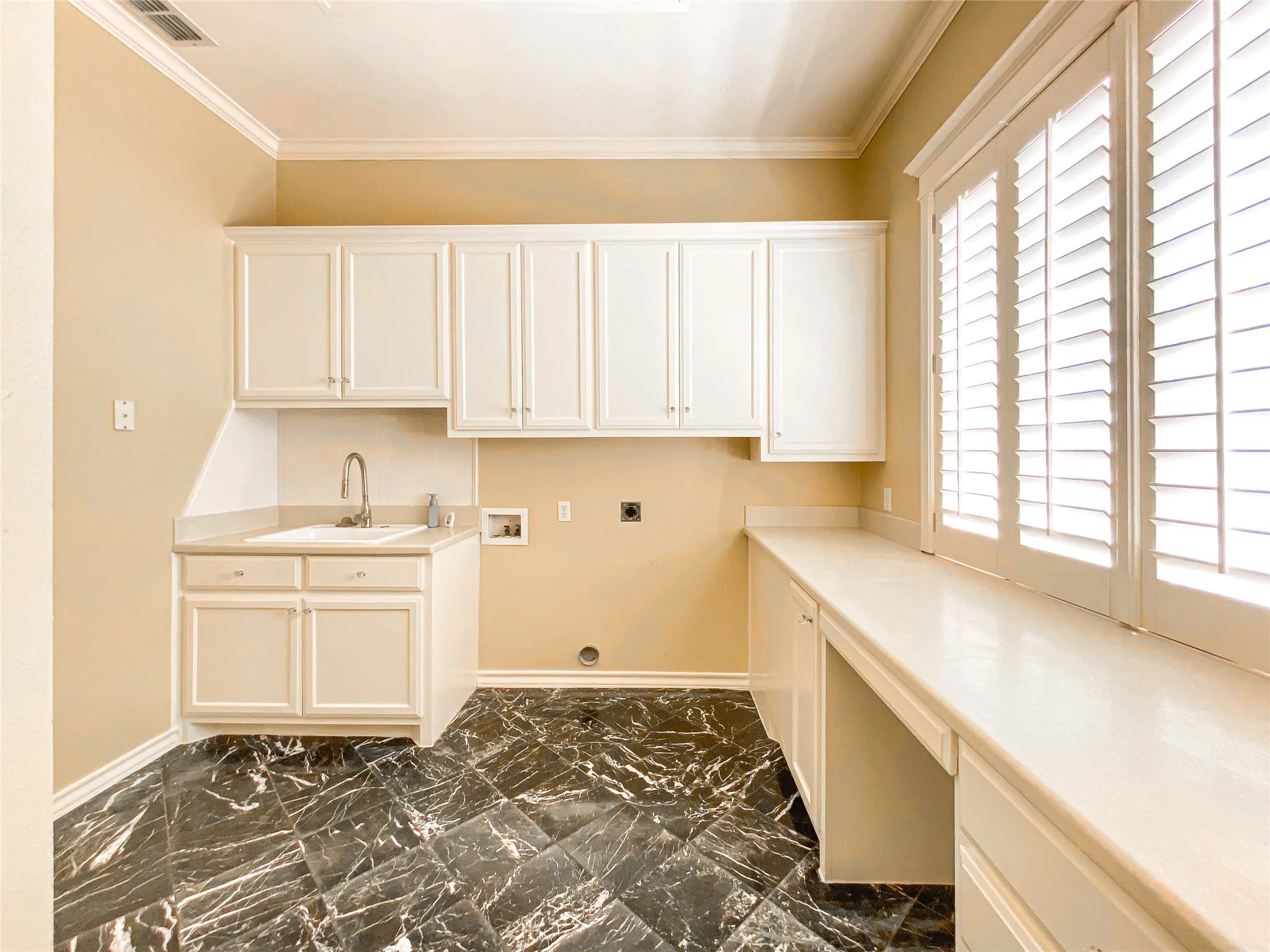 Laundry area with electric dryer hookup, hookup for a washing machine, crown molding, and cabinet space