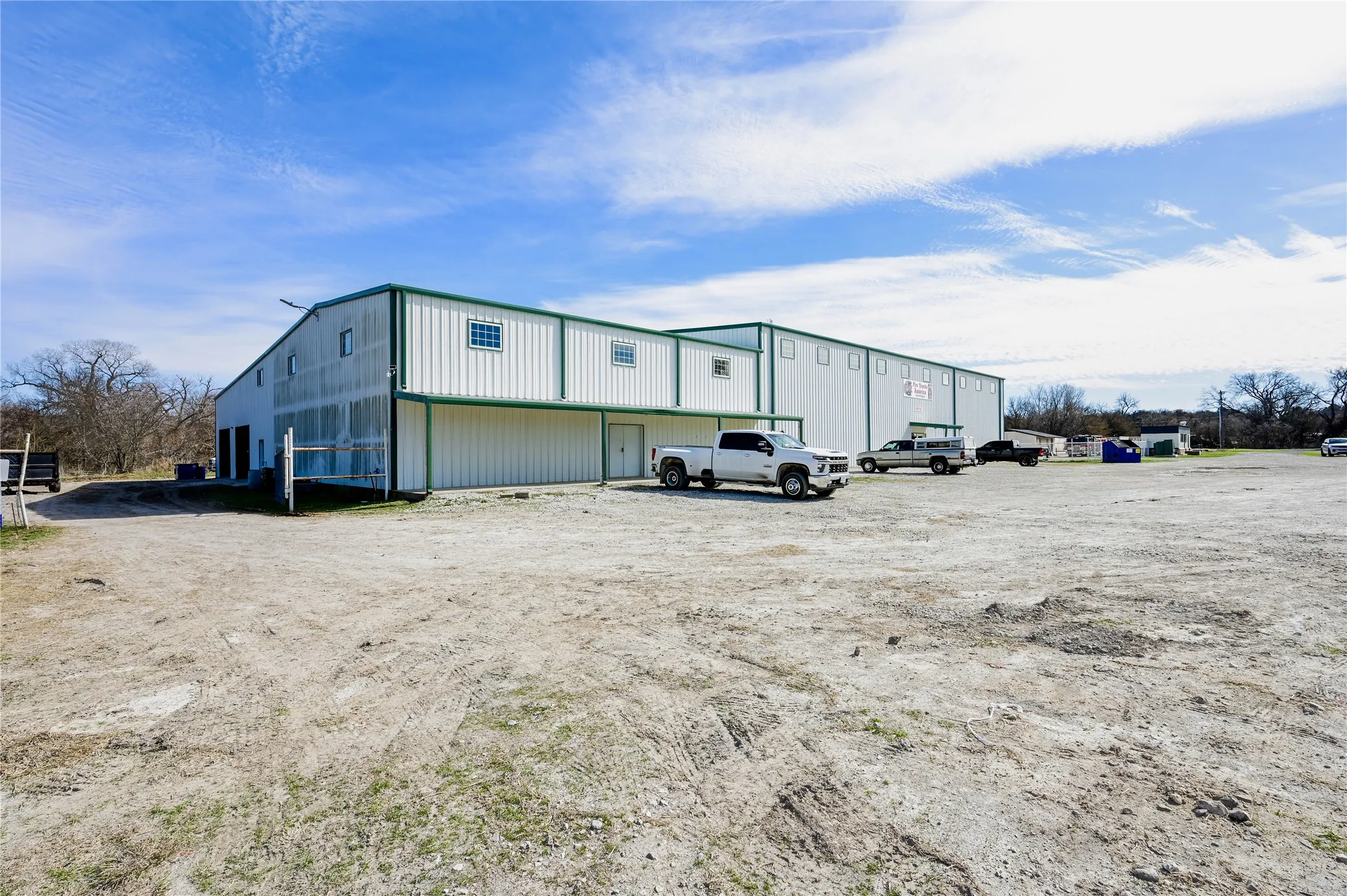 Industrial building with white corrugated metal siding and green trim