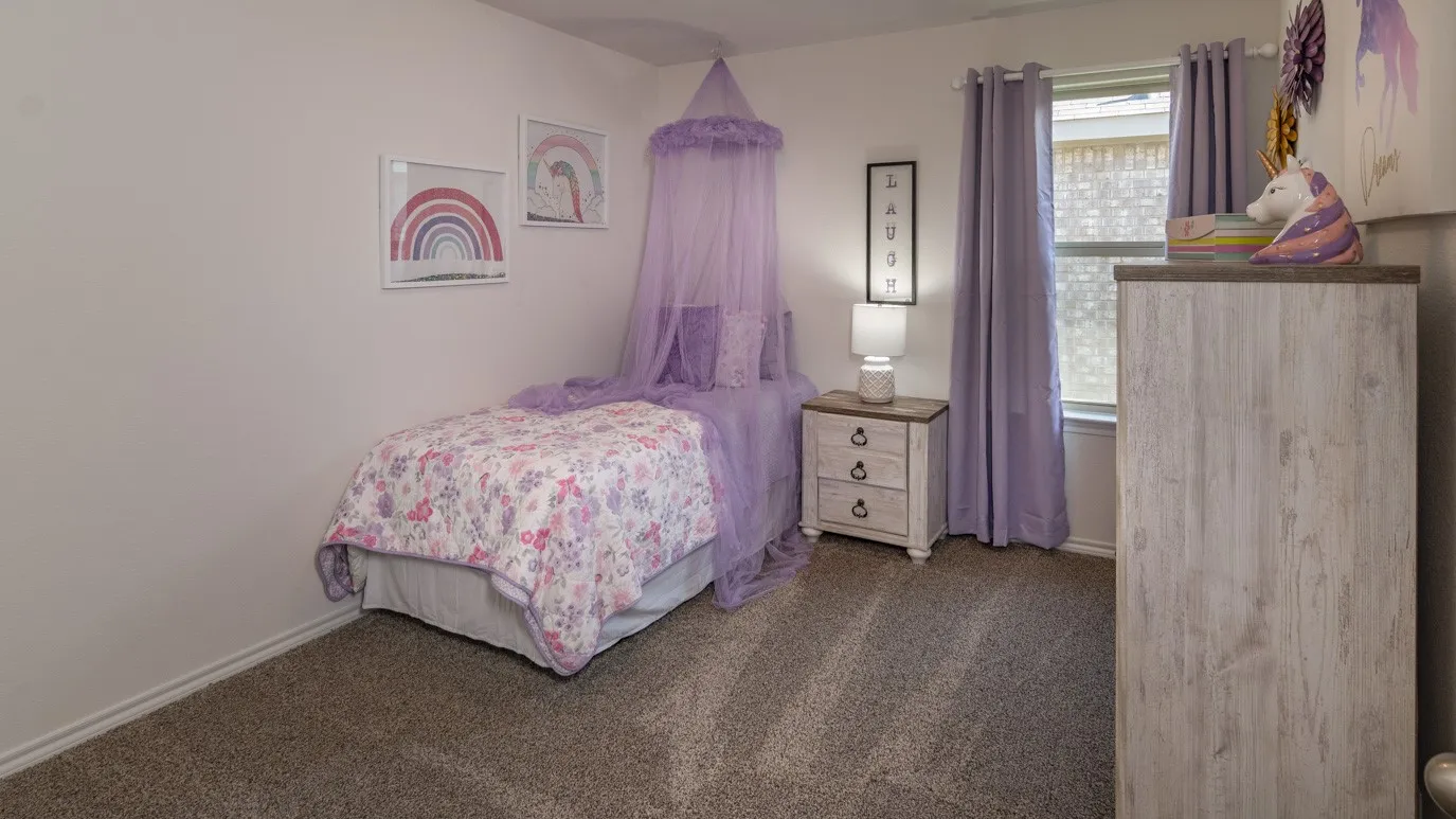 Bedroom with dark carpet and baseboards