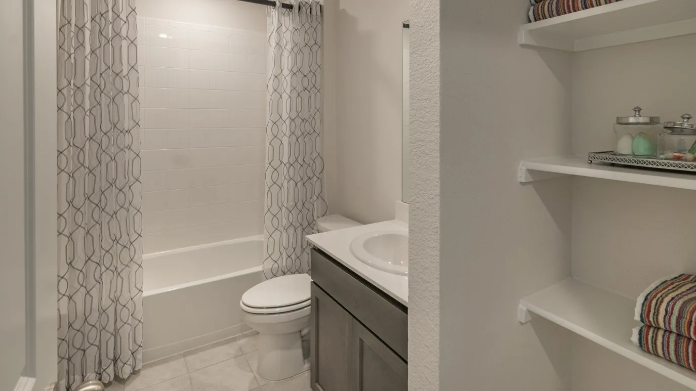 Full bath featuring vanity, shower / bathtub combination with curtain, and light tile patterned floors