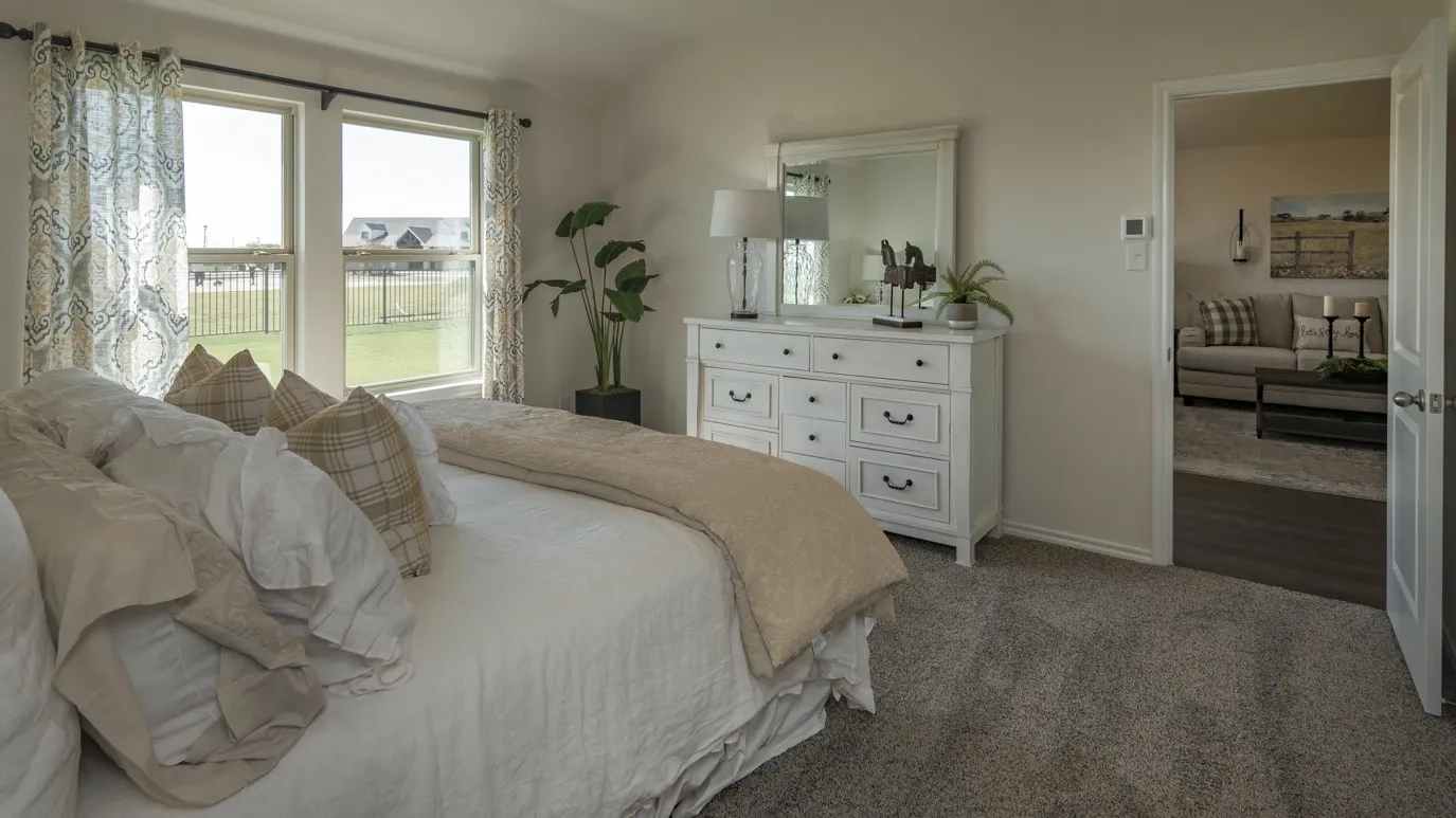 Carpeted bedroom with vaulted ceiling and baseboards