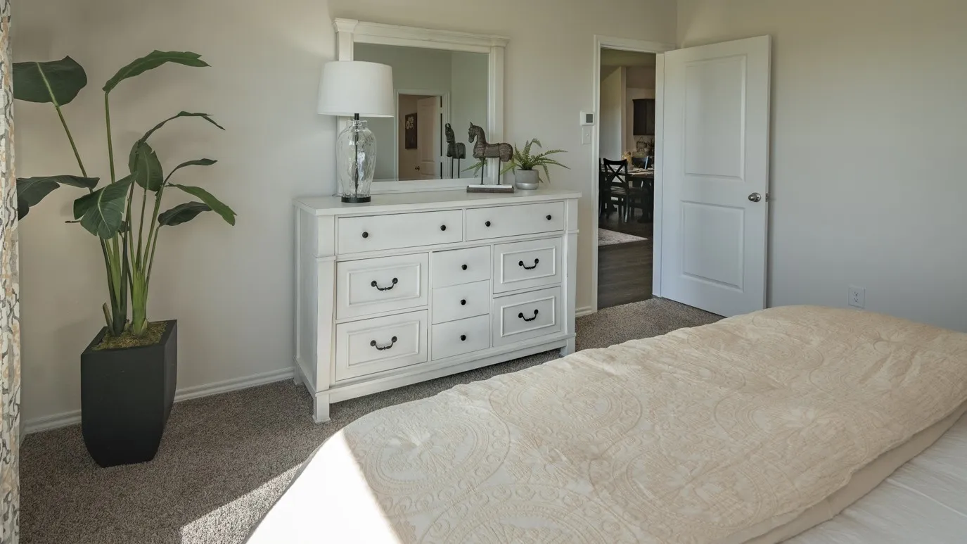 Bedroom with dark carpet and baseboards