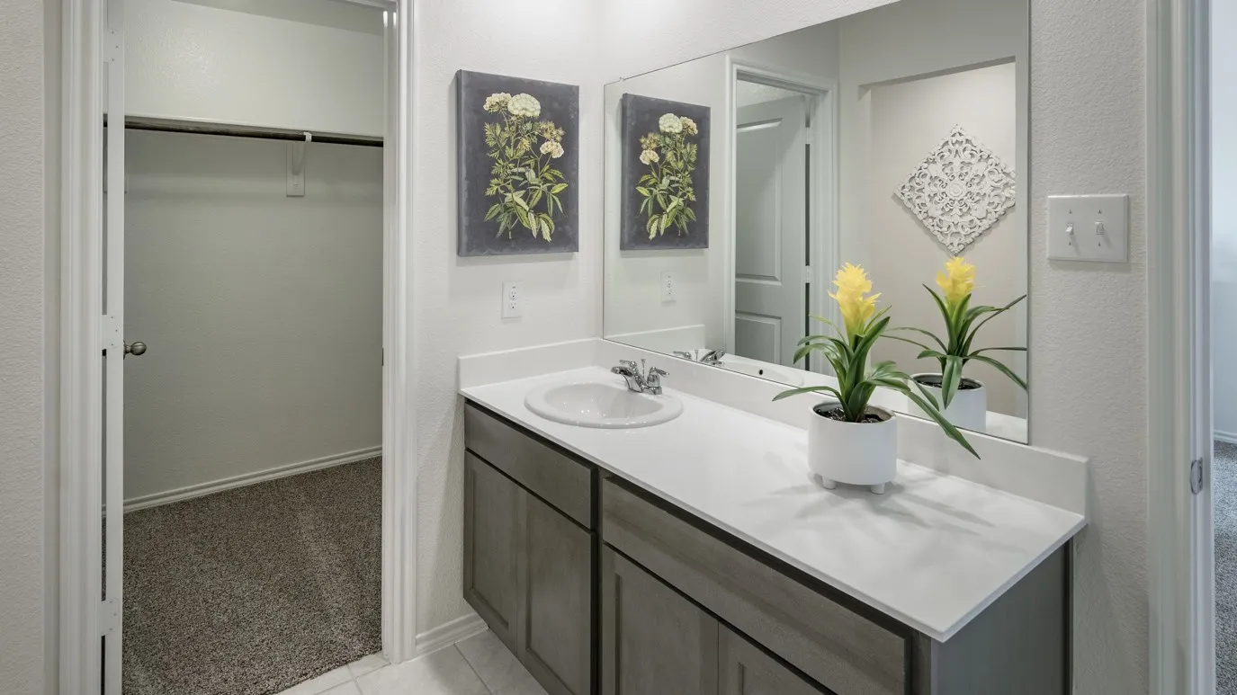 Bathroom with vanity, light carpet, a spacious closet, and a textured wall