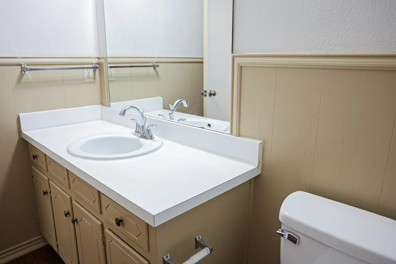 Bathroom vanity featuring a white countertop with an integrated sink and chrome faucet