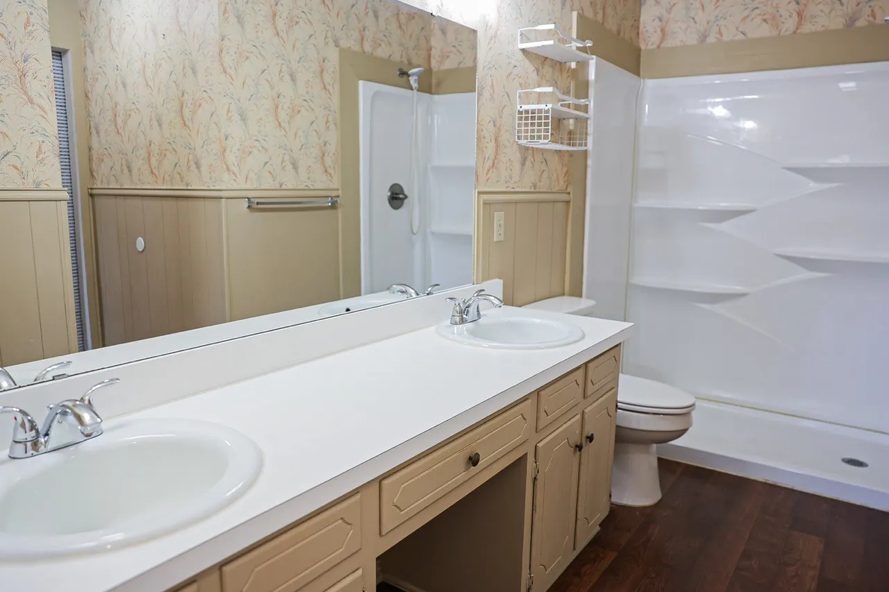 Bathroom featuring a double vanity with integrated sinks, a chrome faucet, and a large wall-mounted mirror