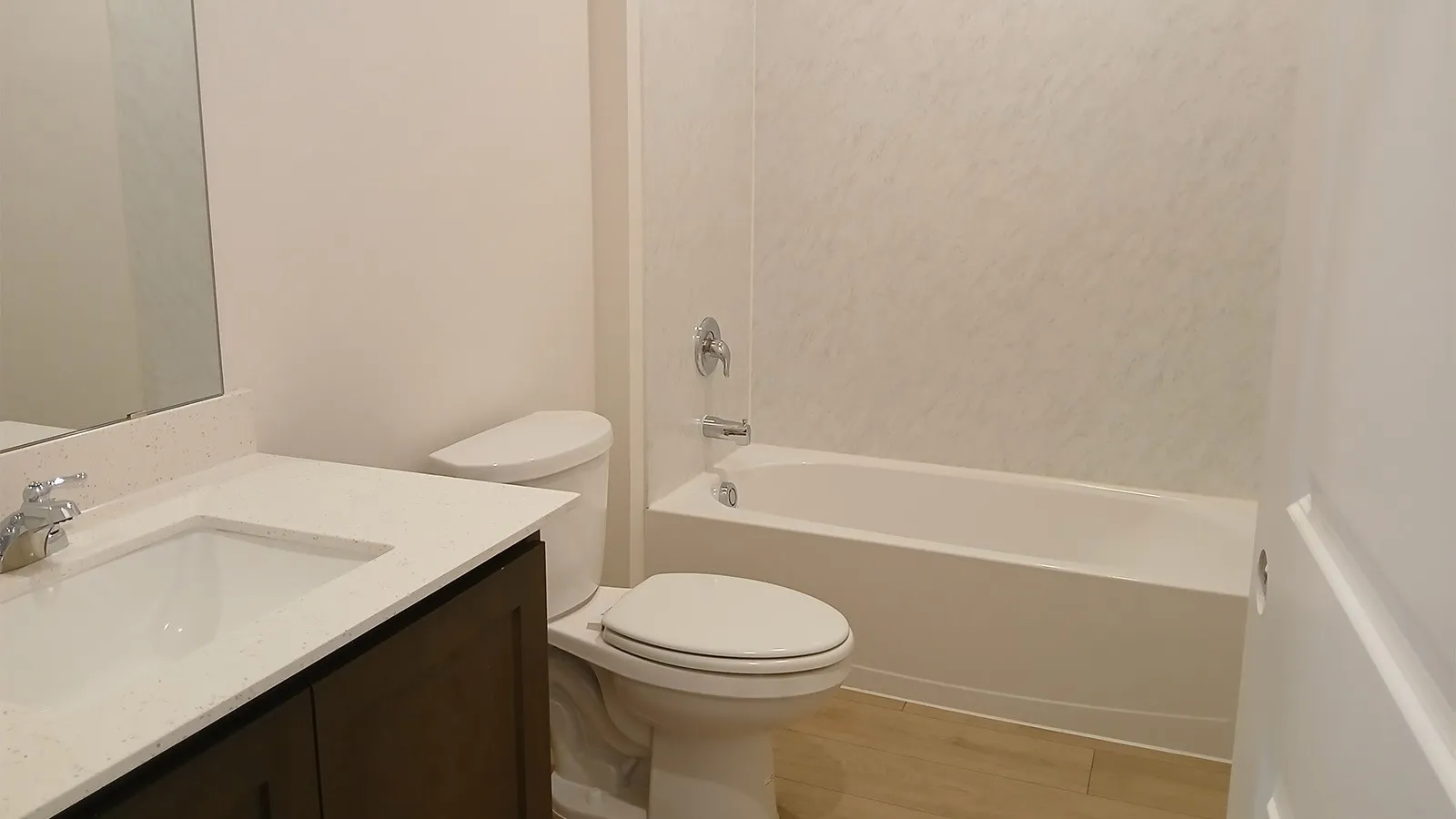 Bathroom featuring a white bathtub, toilet, and vanity with a light-colored countertop