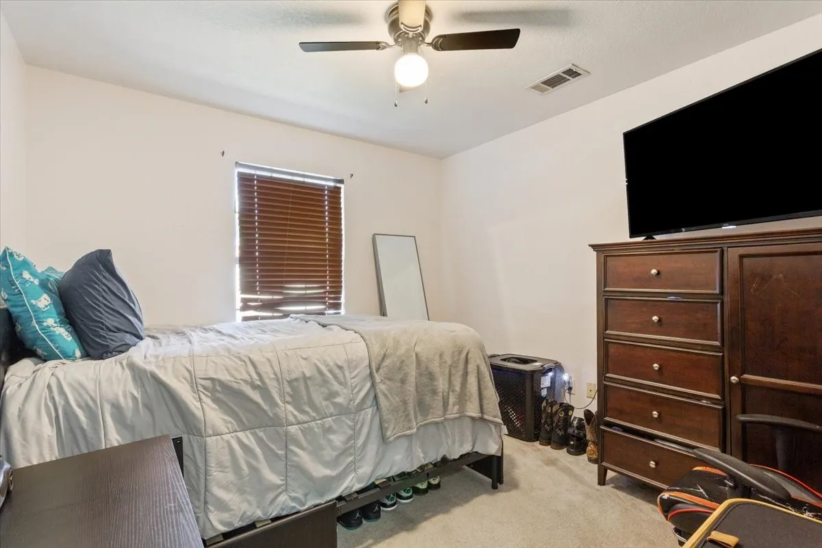 Bedroom with light carpet and ceiling fan
