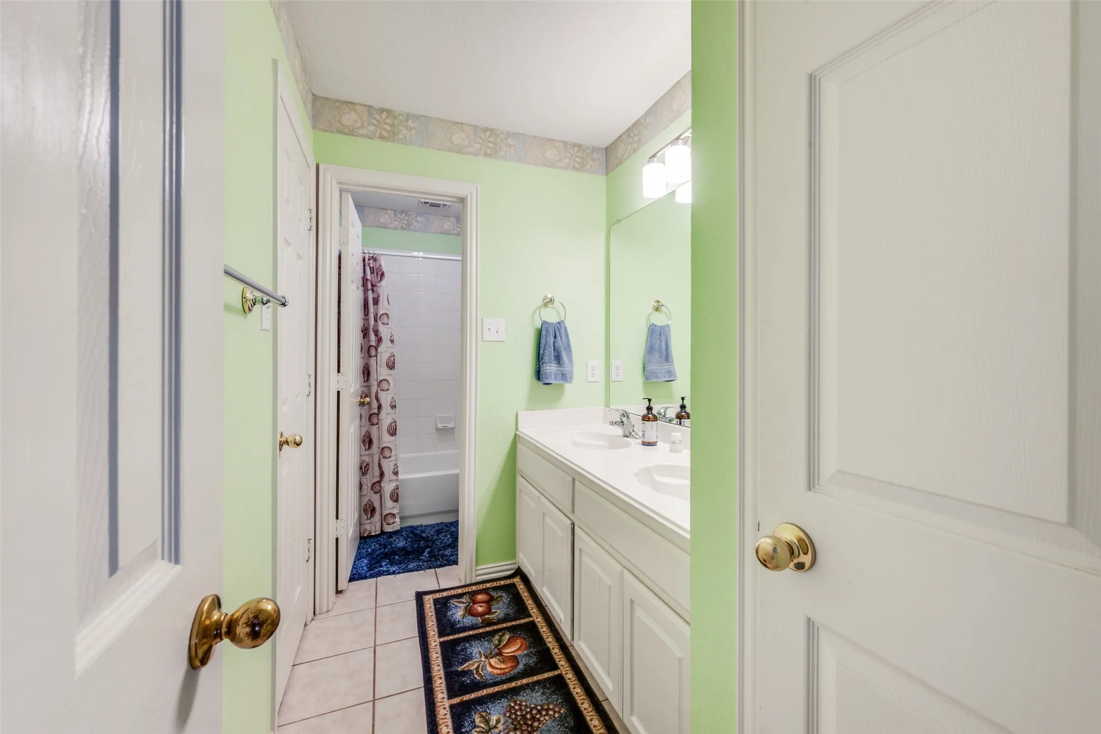 Double vanity with private tub and shower room. This bathroom has a bedroom on each side.