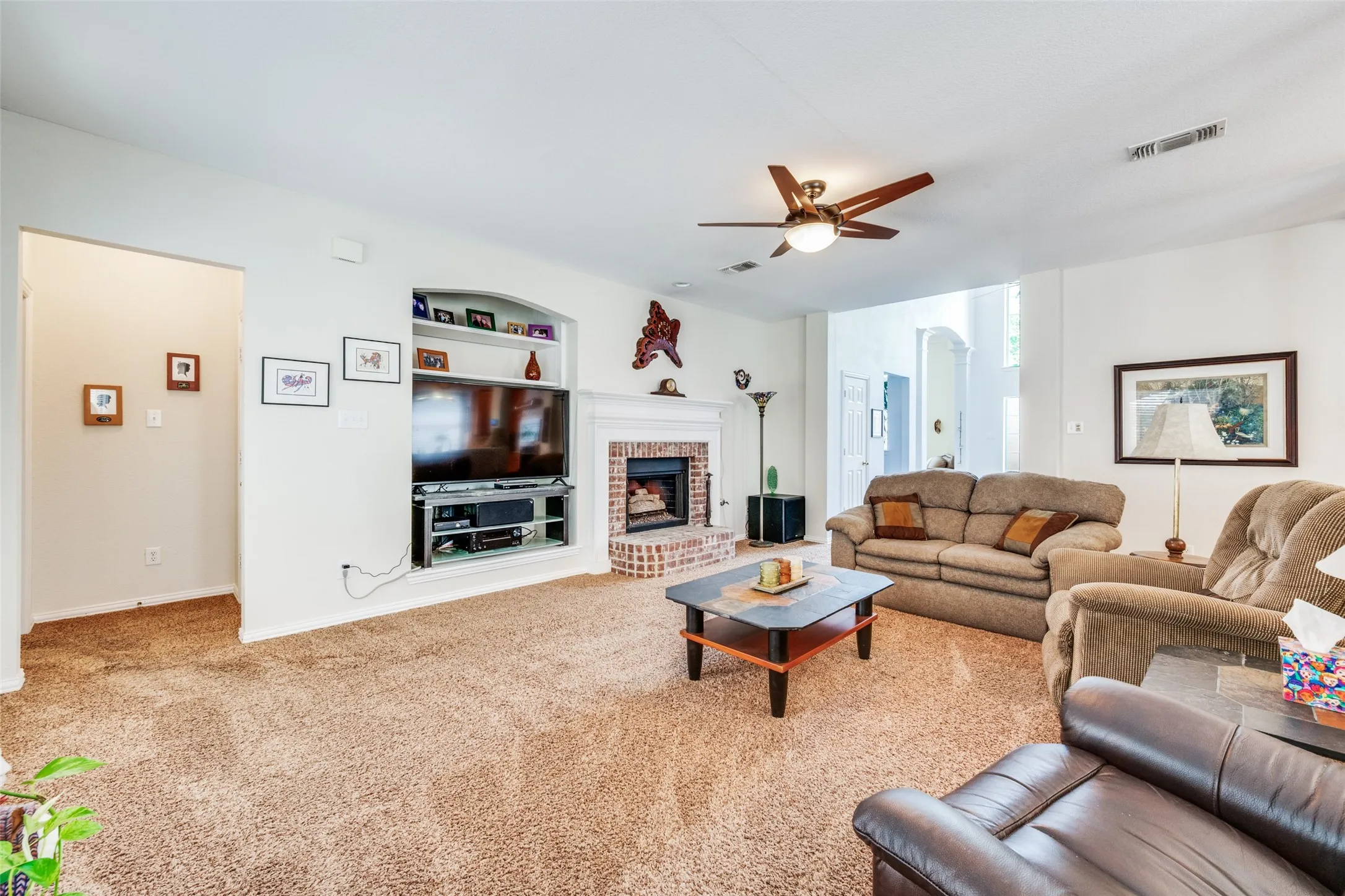 Family room built ins, fire place and shows hall to Primary Suite.