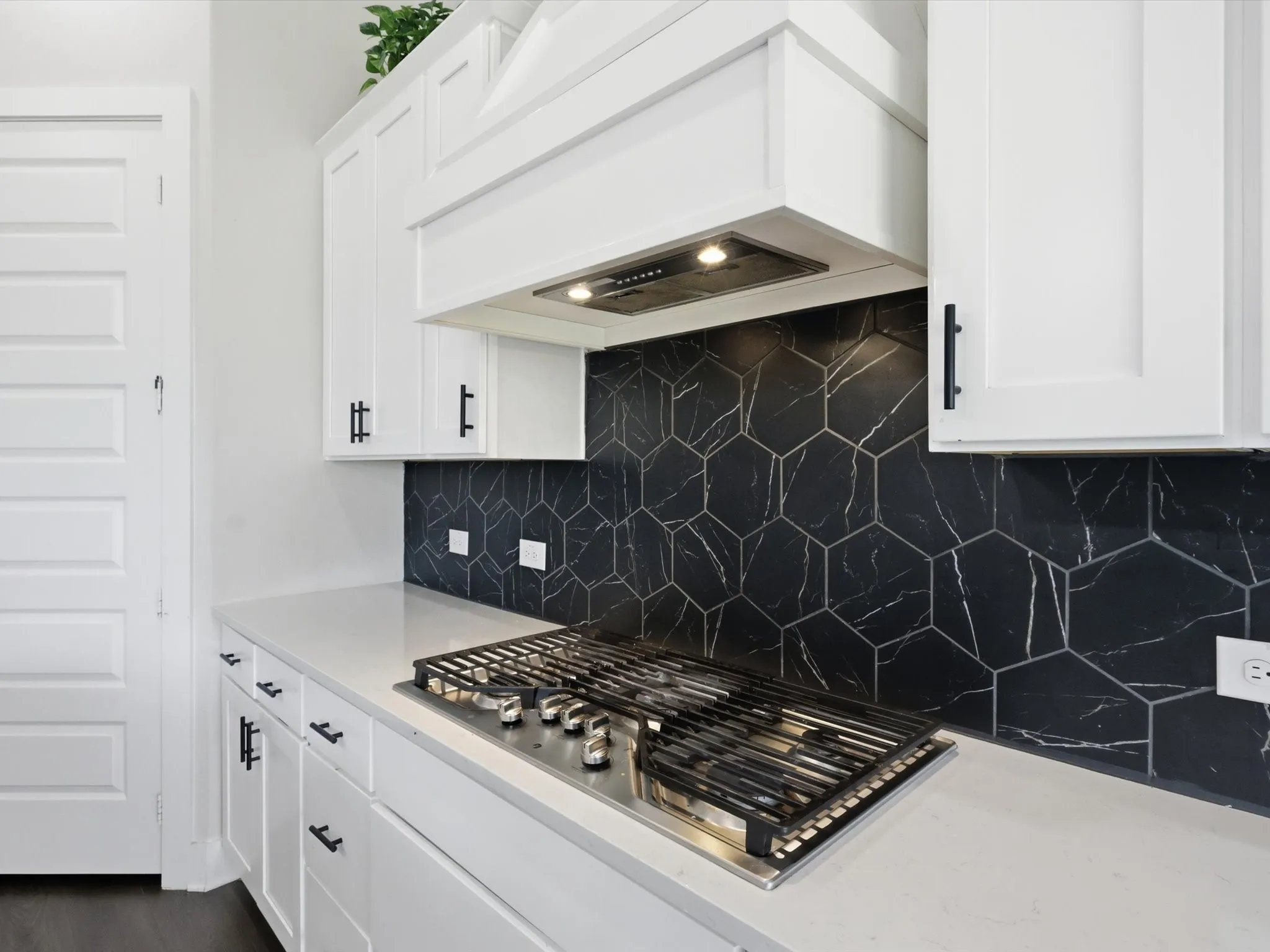 5-burner gas cooktop with designer vent hood and statement tile