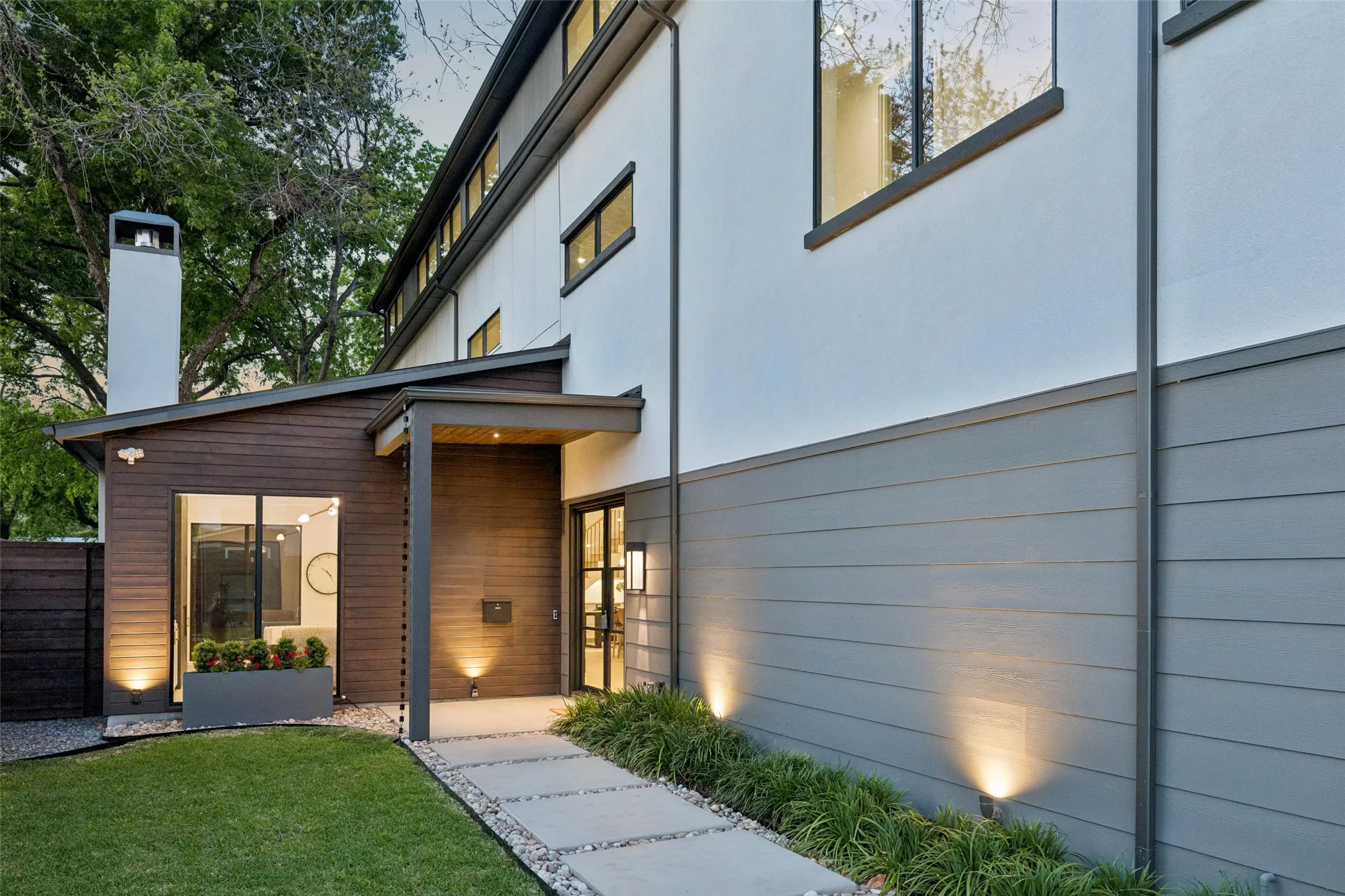 Private covered entry with modern architectural details and warm exterior lighting, creating a welcoming first impression.