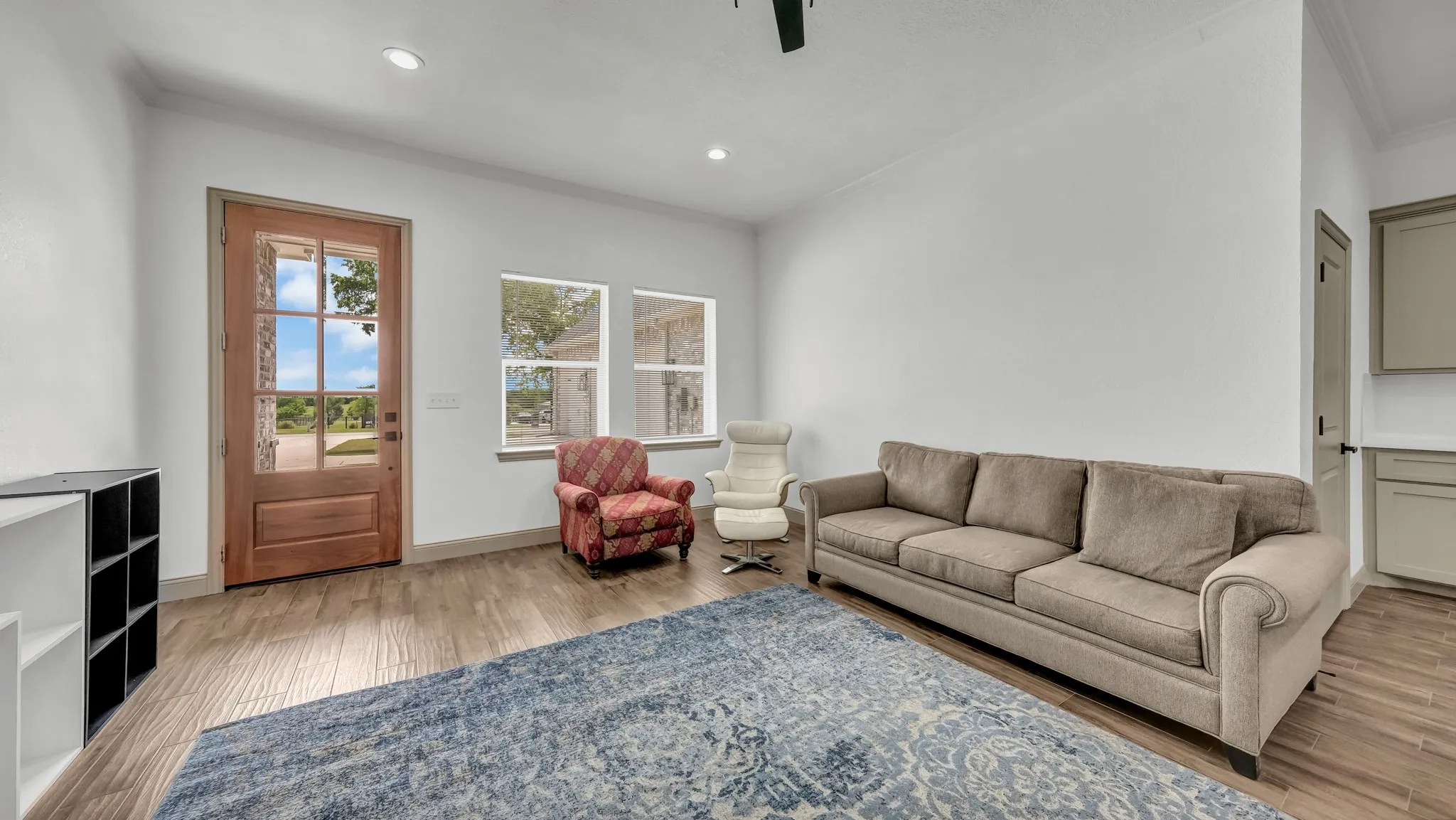 Living room featuring light wood-type flooring, crown molding, recessed lighting, and ceiling fan