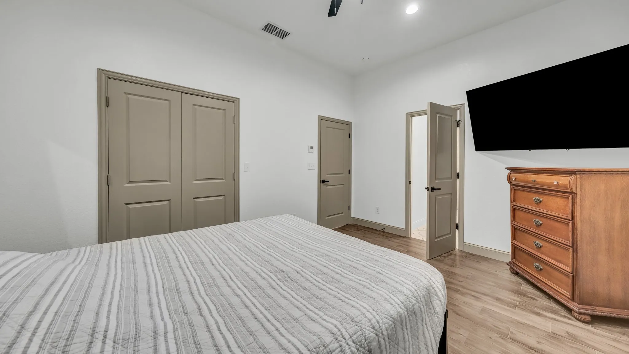 Bedroom featuring a ceiling fan, light wood-style floors, and a closet