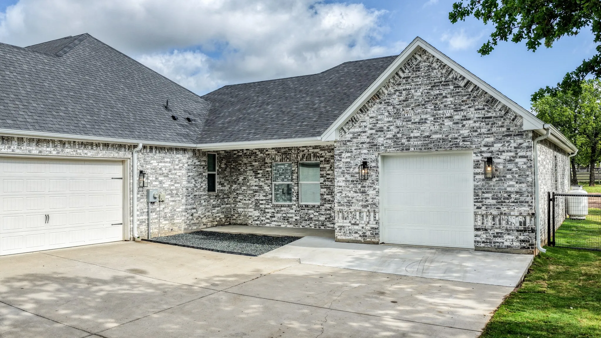 Ranch-style house featuring an attached garage, brick siding, and driveway