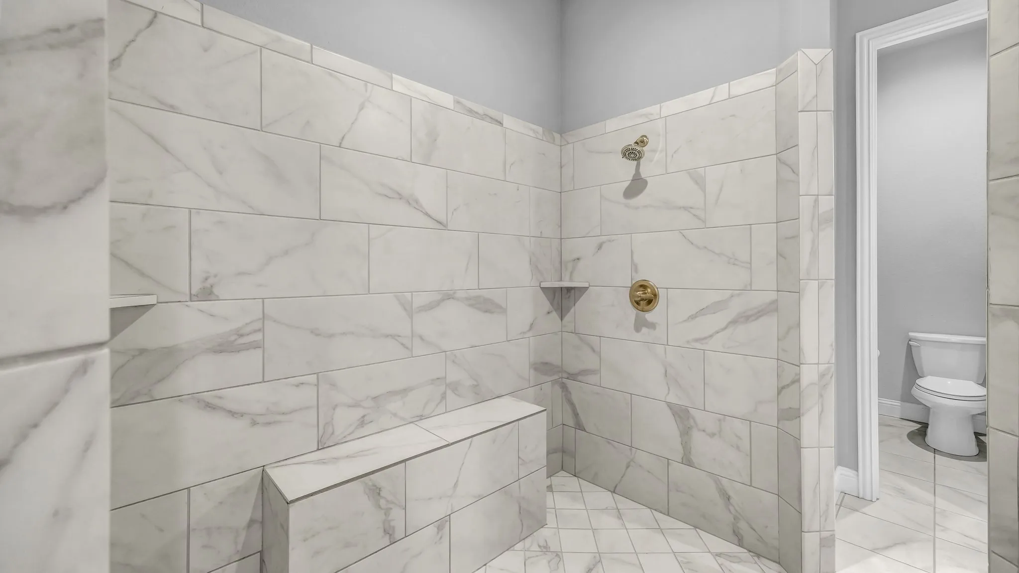 Full bathroom featuring toilet and tiled shower