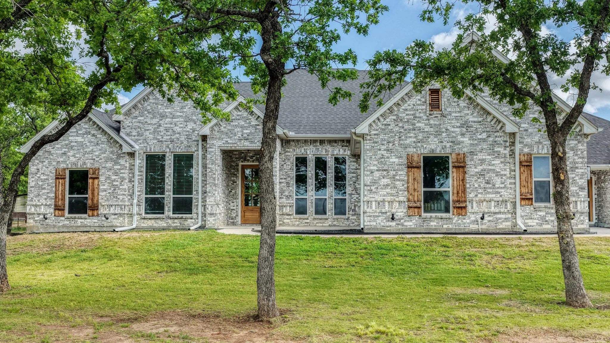 View of front facade featuring a front yard and brick siding