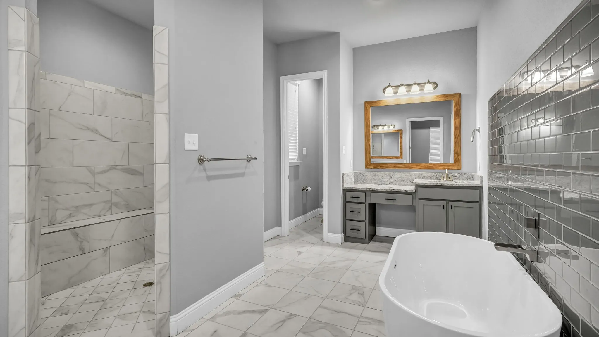 Full bath with vanity, light marble finish floors, a soaking tub, and a walk in shower