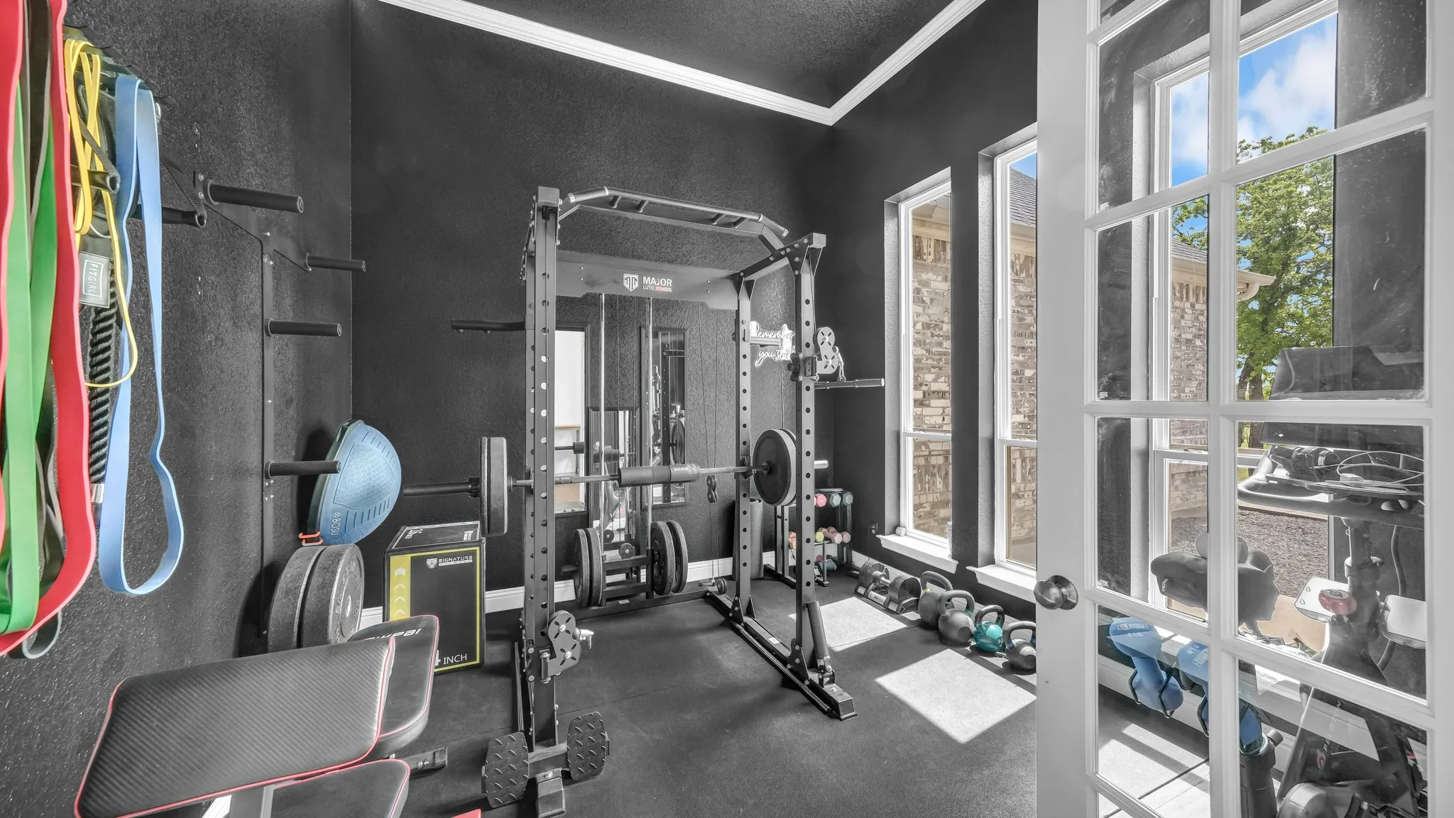 Exercise area with crown molding and dark rubber floors
