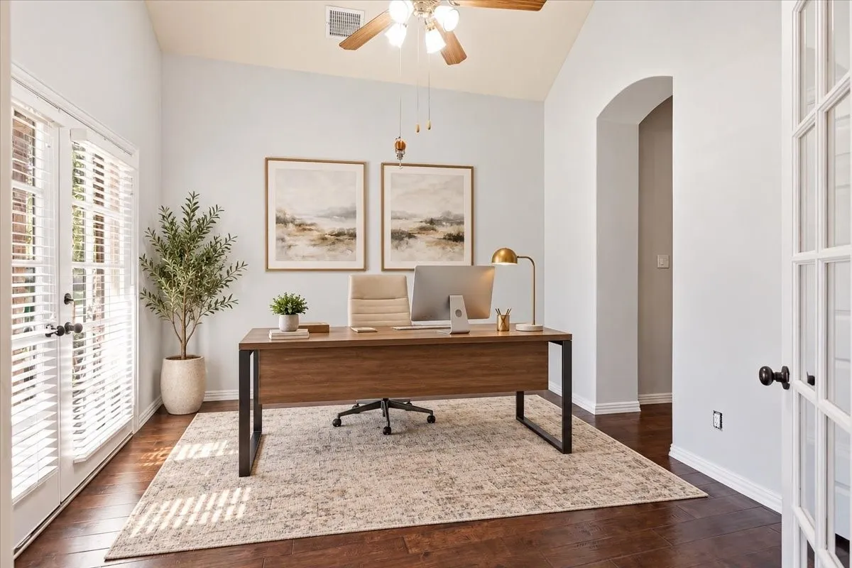 Vaulted ceiling, wood-finish flooring, ceiling fan, French doors with louvered blinds, and an arched entryway