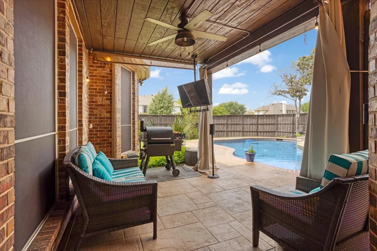 View of pool with area for grilling, patio surround, and a fenced backyard