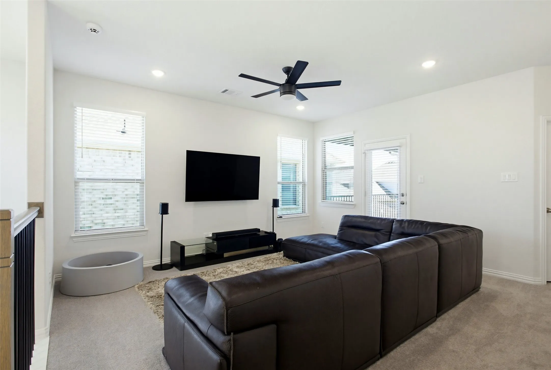 Spacious secondary living area featuring plush carpet flooring, recessed lighting, and a modern ceiling fan