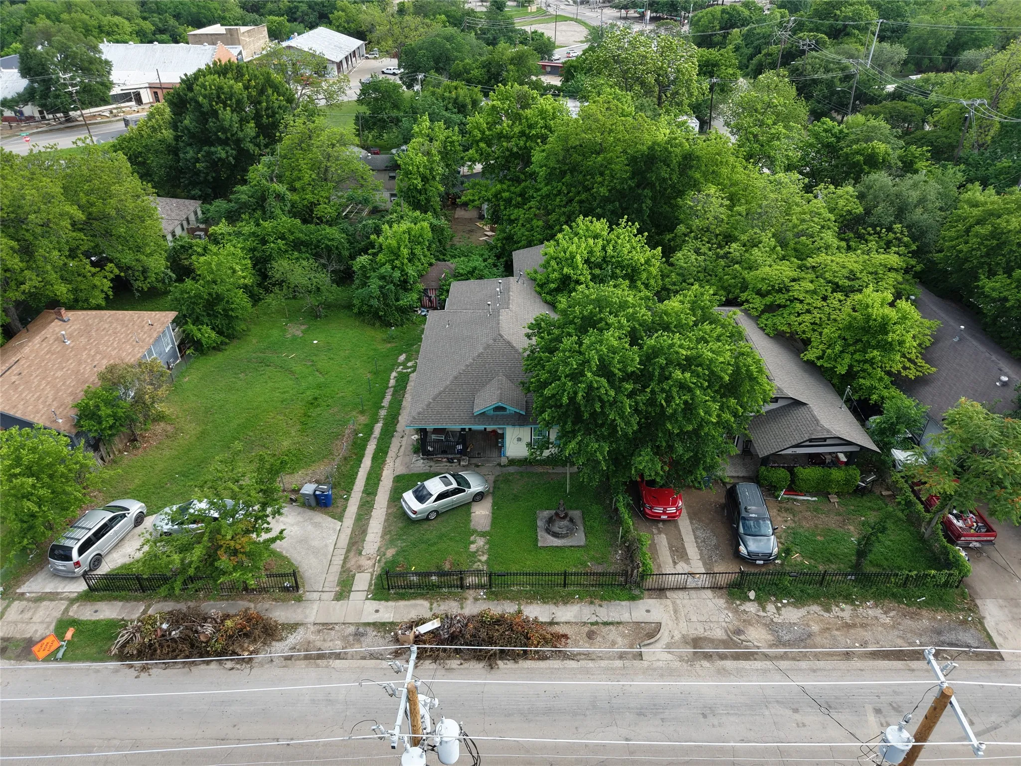 Two properties featuring pitched roofs, mature trees, and street-side access