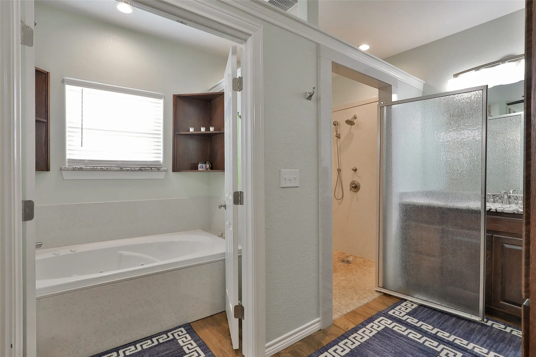 Separate soaking tub and walk-in shower with multiple shower heads, mold free sealing, and extra built-in storage on both vanities