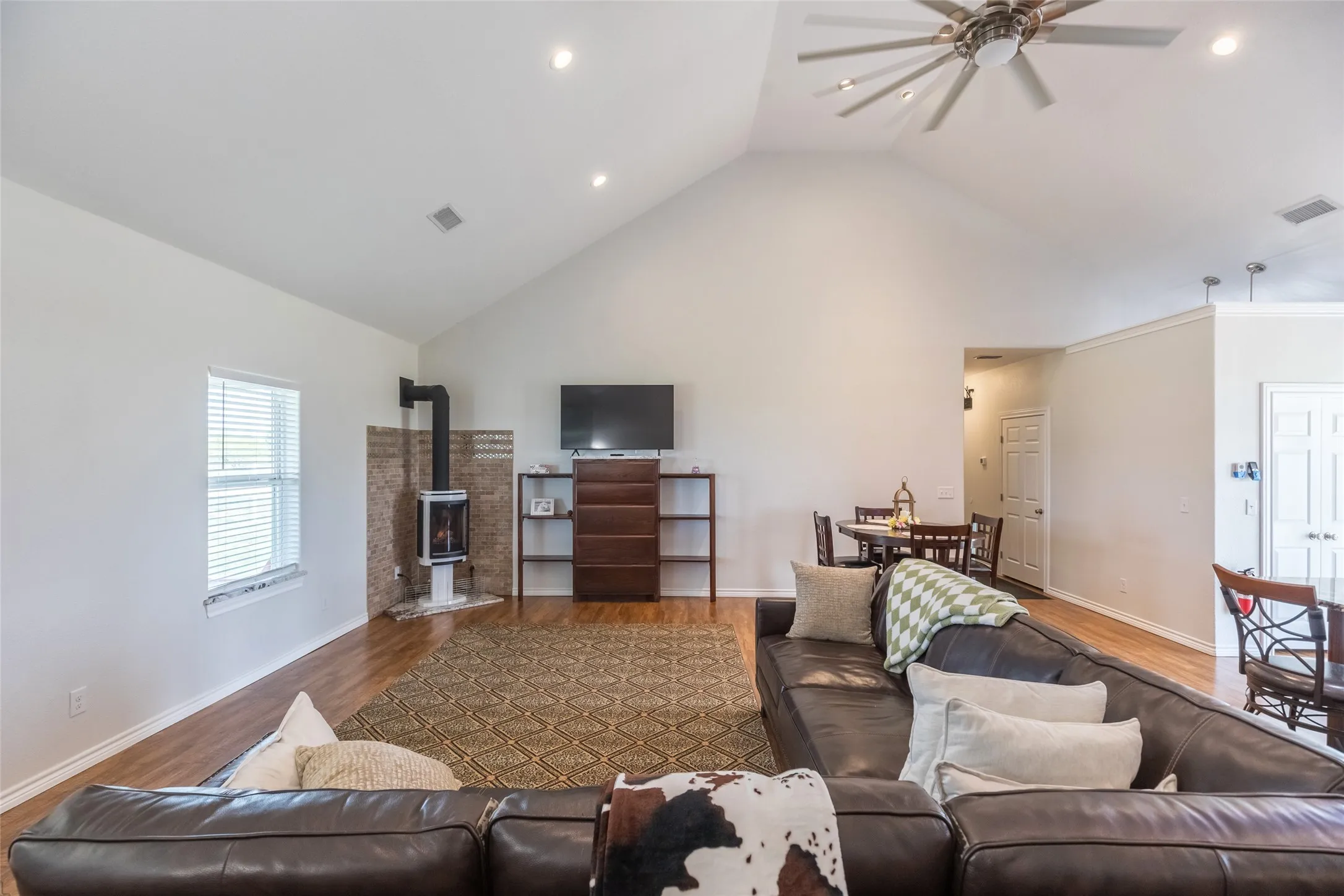 Open living area with built in shelving, propane Yodel fireplace, all dimmable lighting, and more