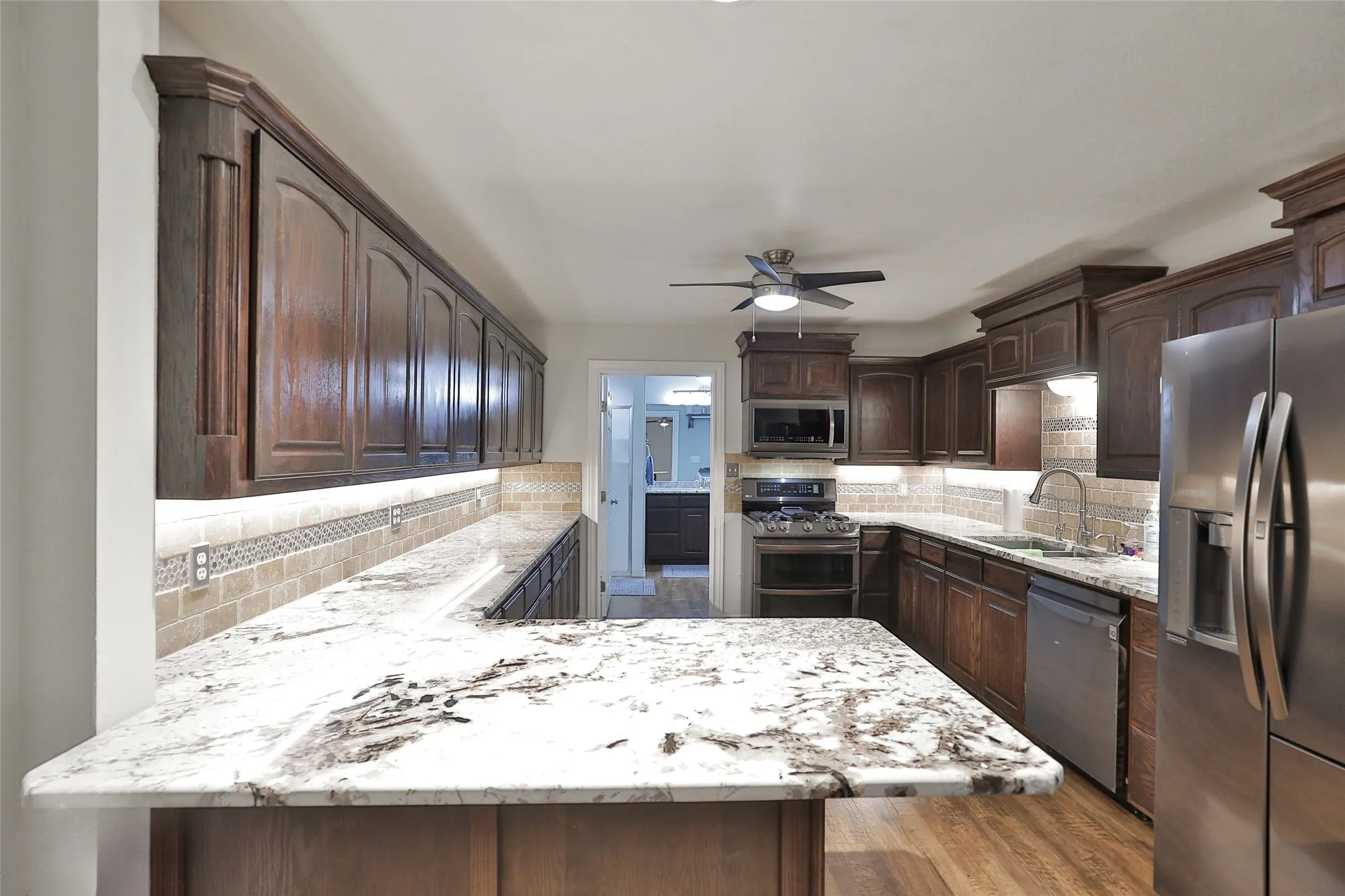 Full kitchen in warehouse/man mansion looking into the downstairs full bathroom and laundry area. All appliances can convey! Ready for you!