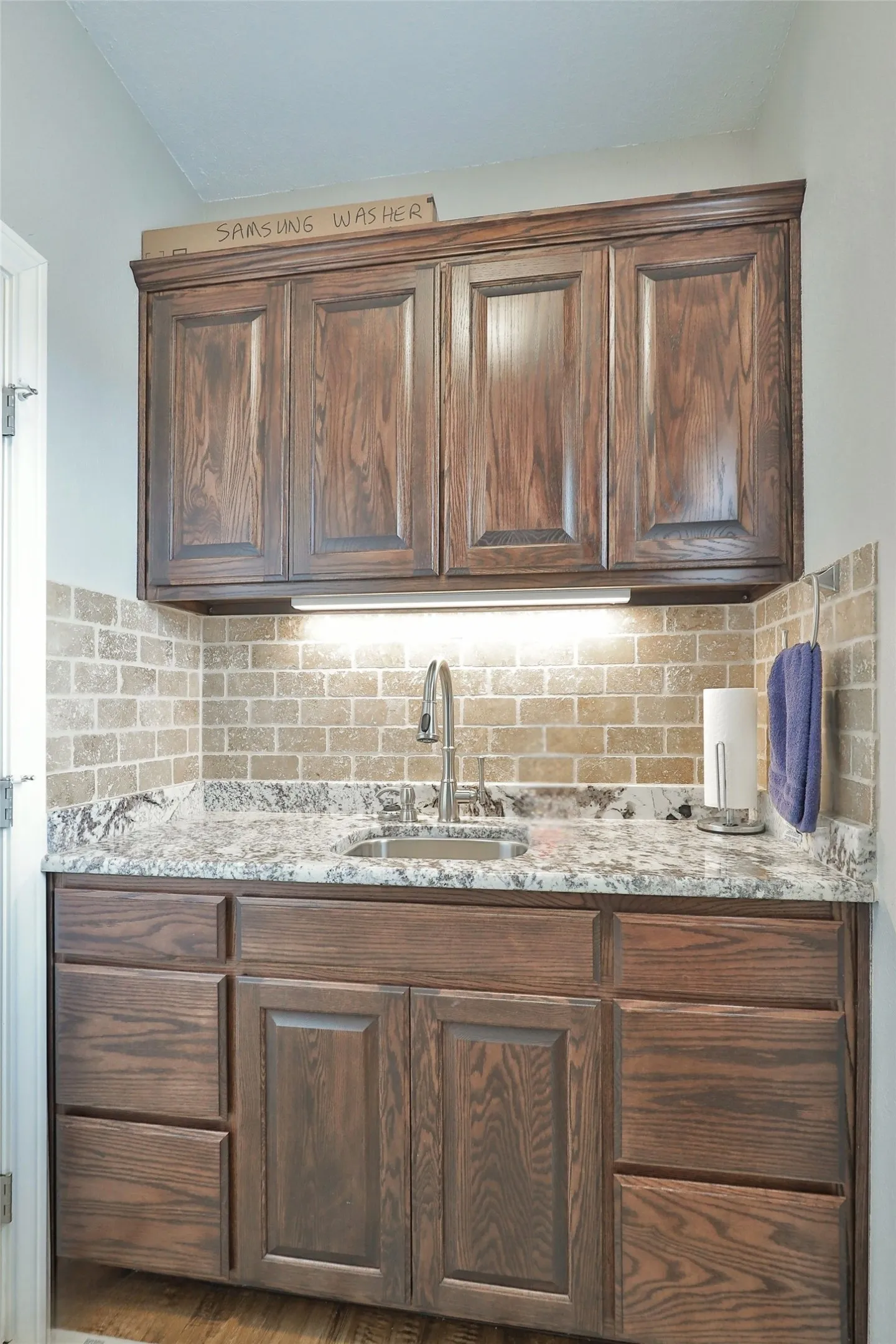 Individual Laundry Area with Sink and Built-In Cabinetry