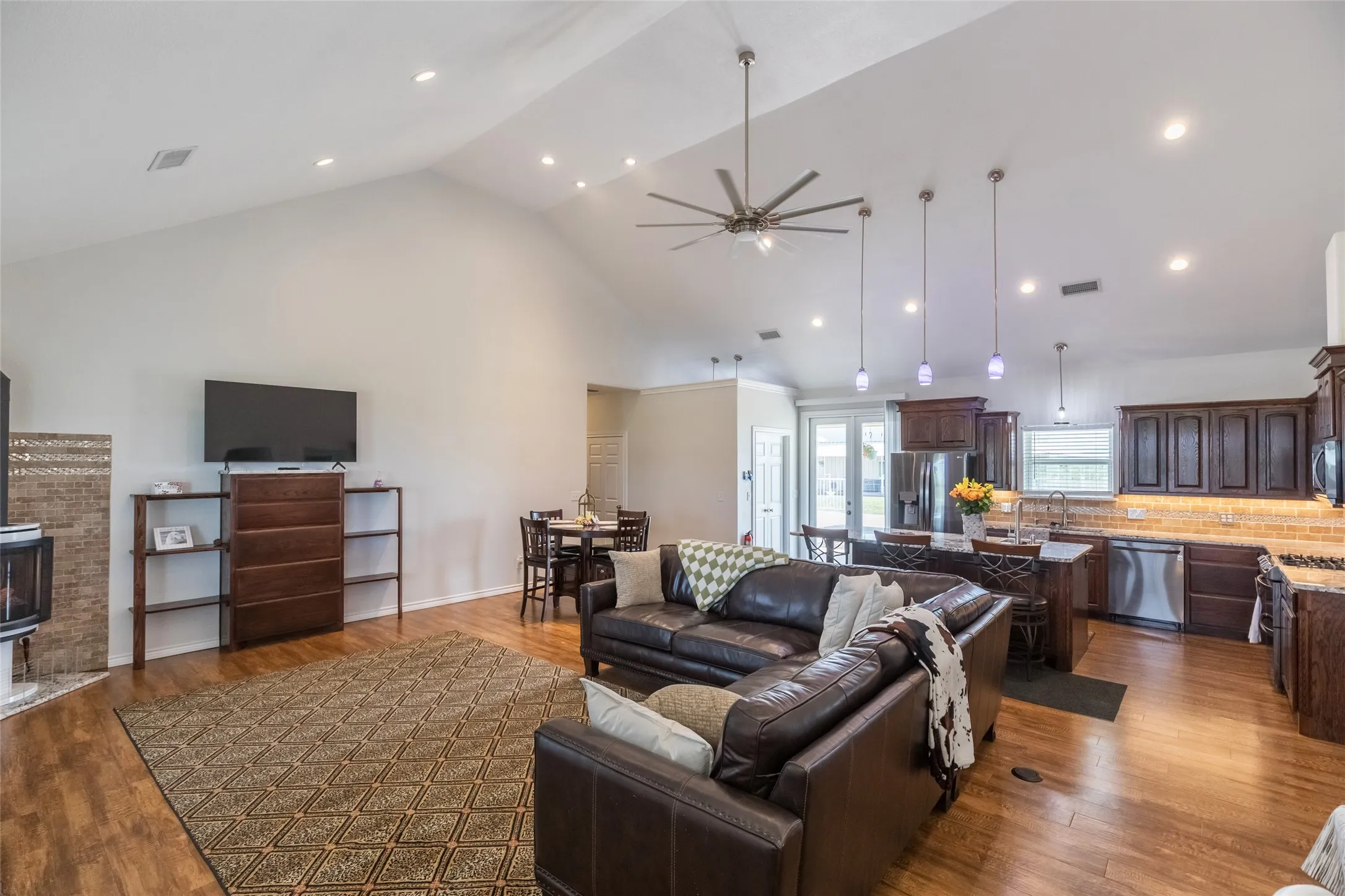 Open living area with built in shelving, propane Yodel fireplace, all dimmable lighting, and more