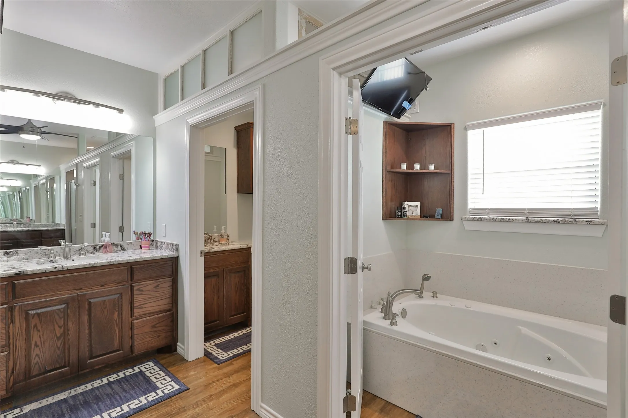Primary bathroom with 2 separate vanities, soaking tub with french doors, TV all set up and ready for YOU!