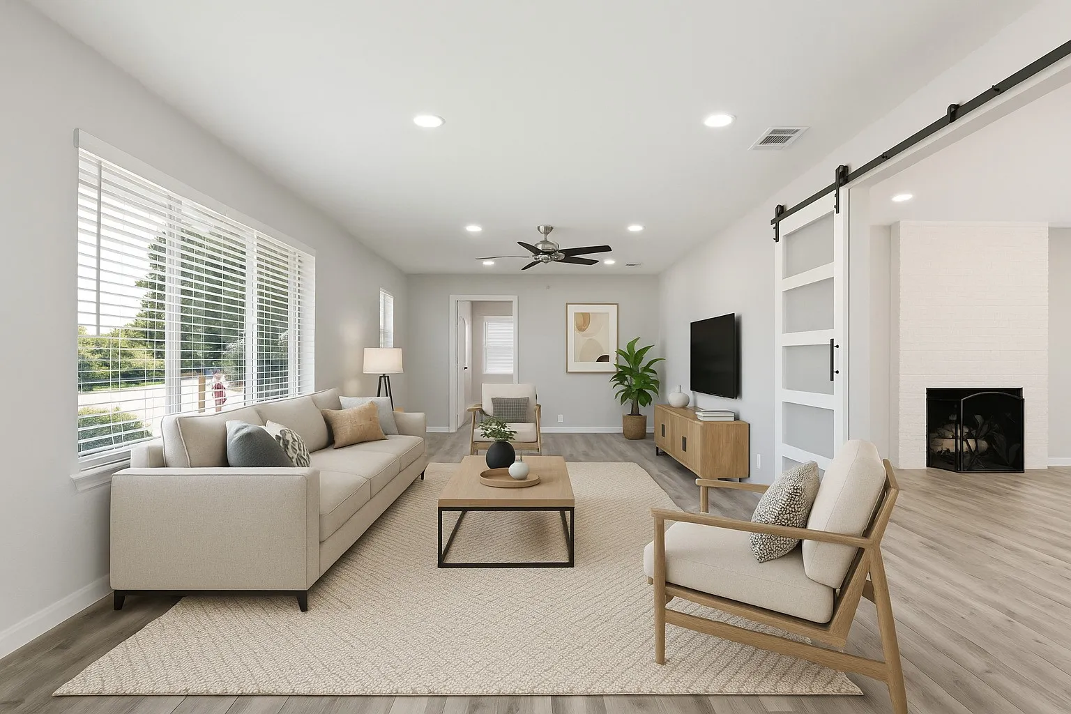 Living area with a ceiling fan, a barn door, recessed lighting, built in shelves, and a large fireplace