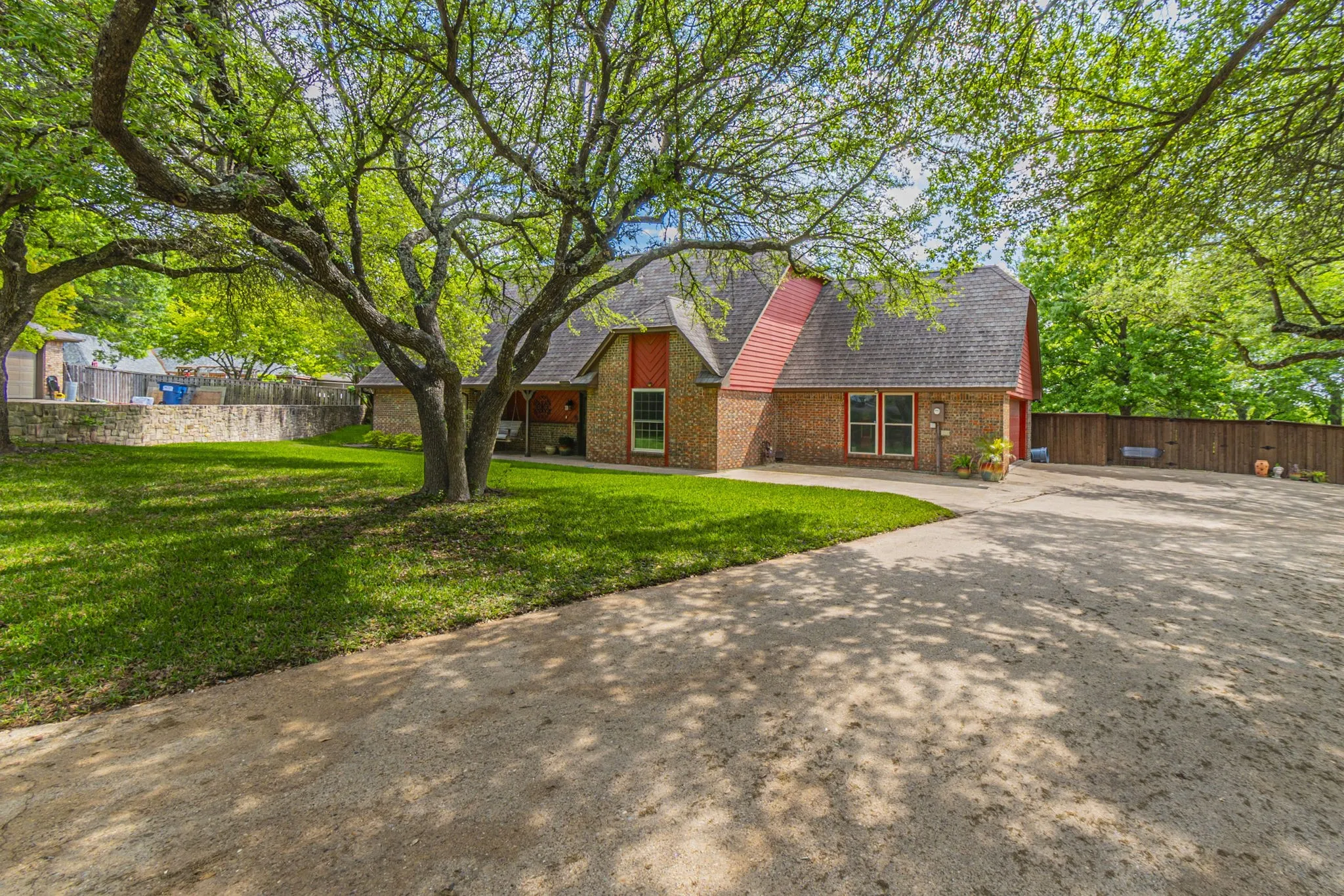 View of front of home with driveway, a shingled roof, and brick siding
