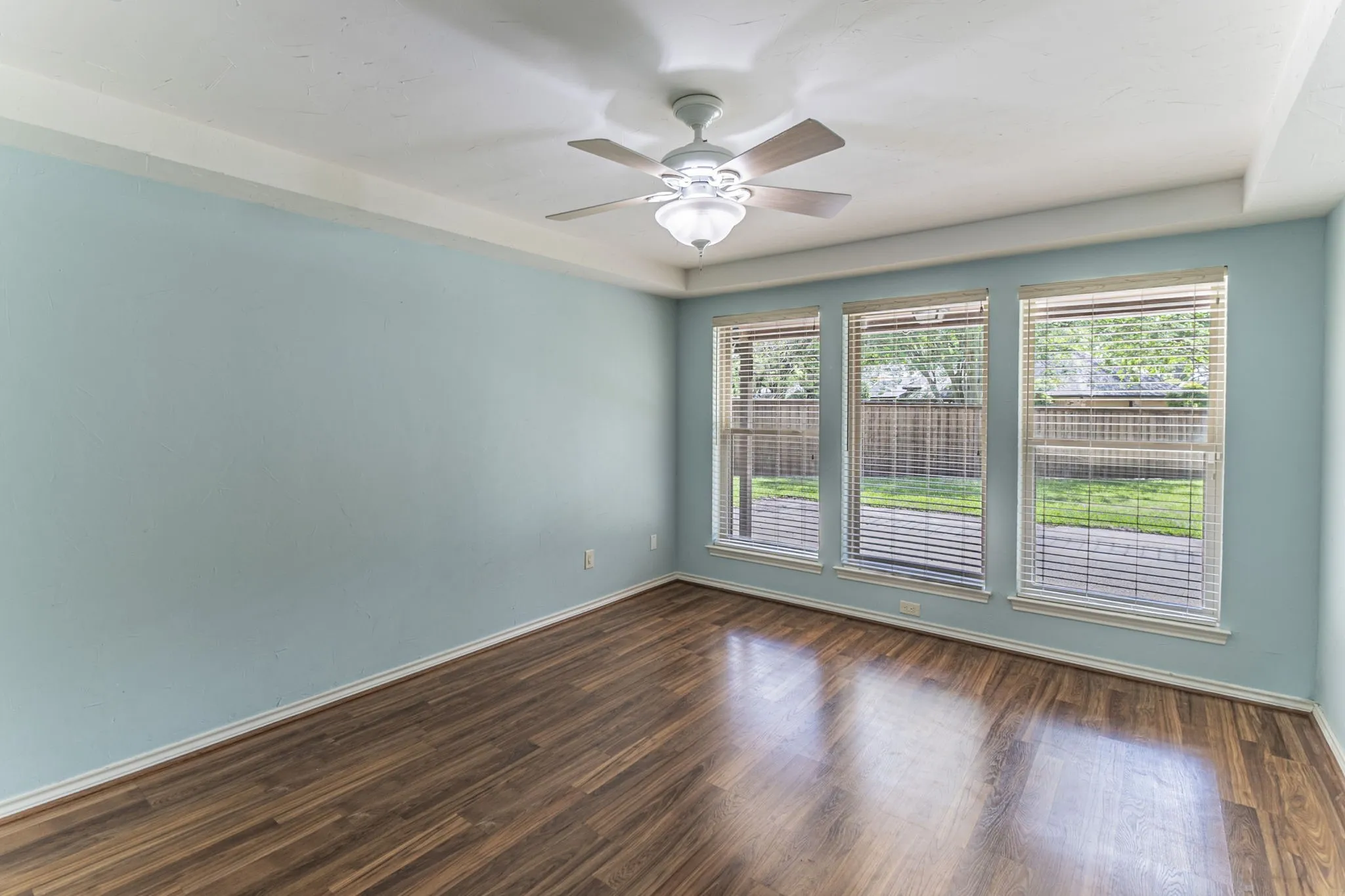 Spare room featuring dark wood-type flooring and ceiling fan