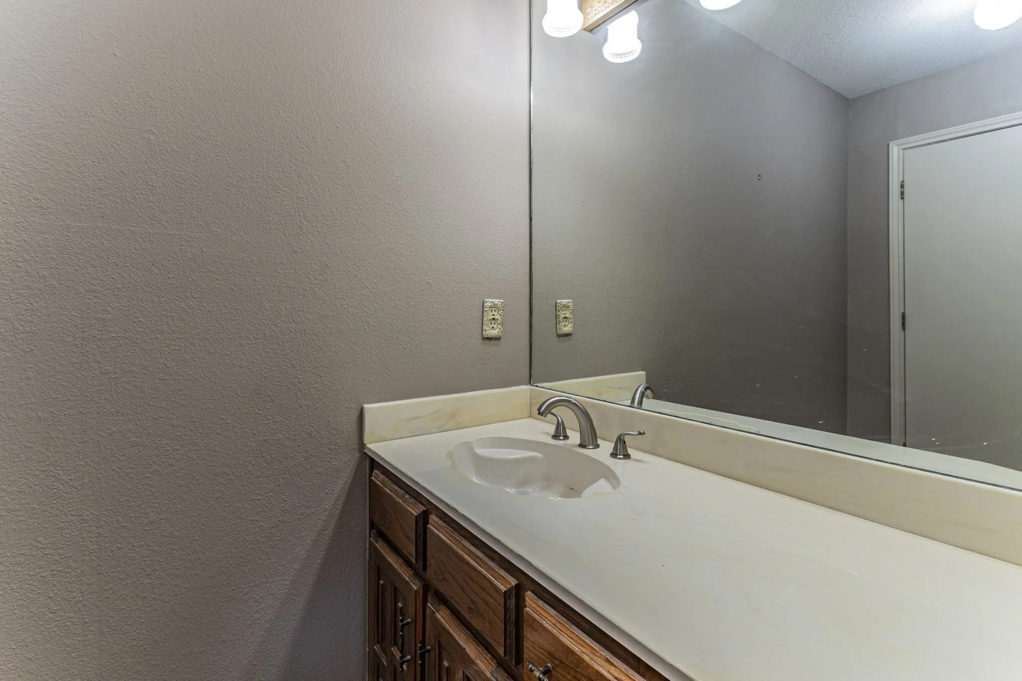 Bathroom with vanity and a textured wall