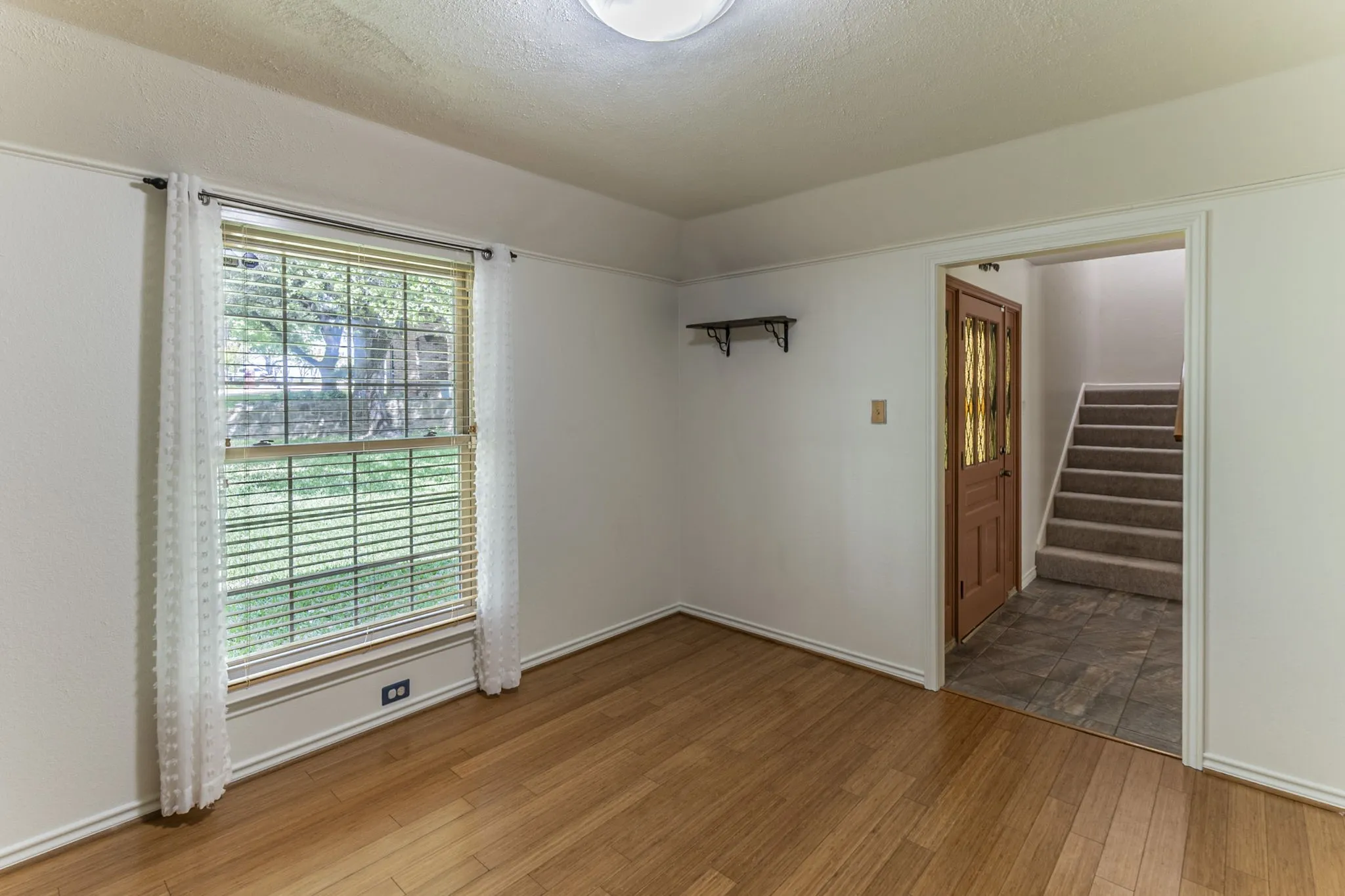 Empty room with a textured ceiling and light wood-type flooring