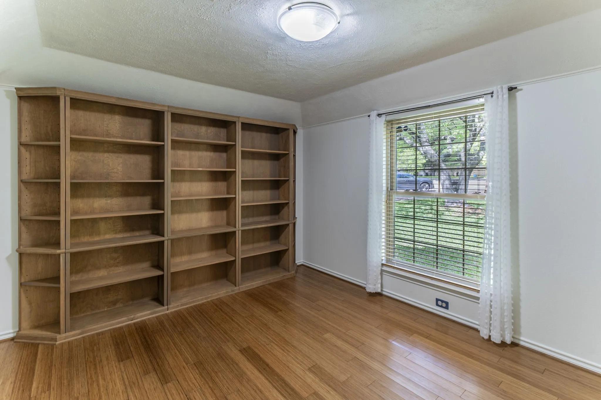 Unfurnished room with light wood finished floors and a textured ceiling