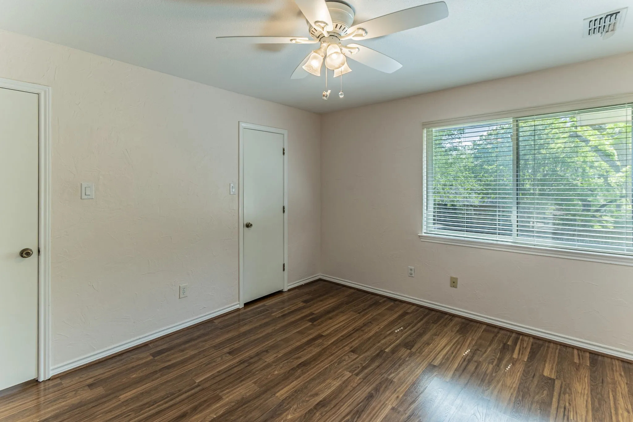 Unfurnished bedroom with dark wood-type flooring and a ceiling fan