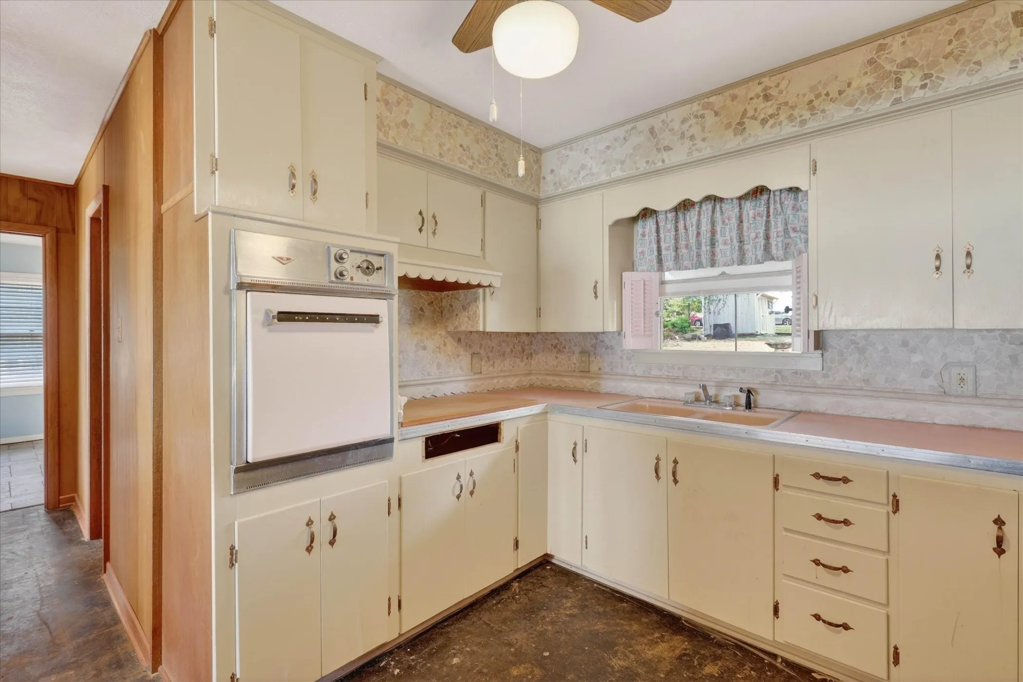 Kitchen with cream cabinets, original oven from 1960.