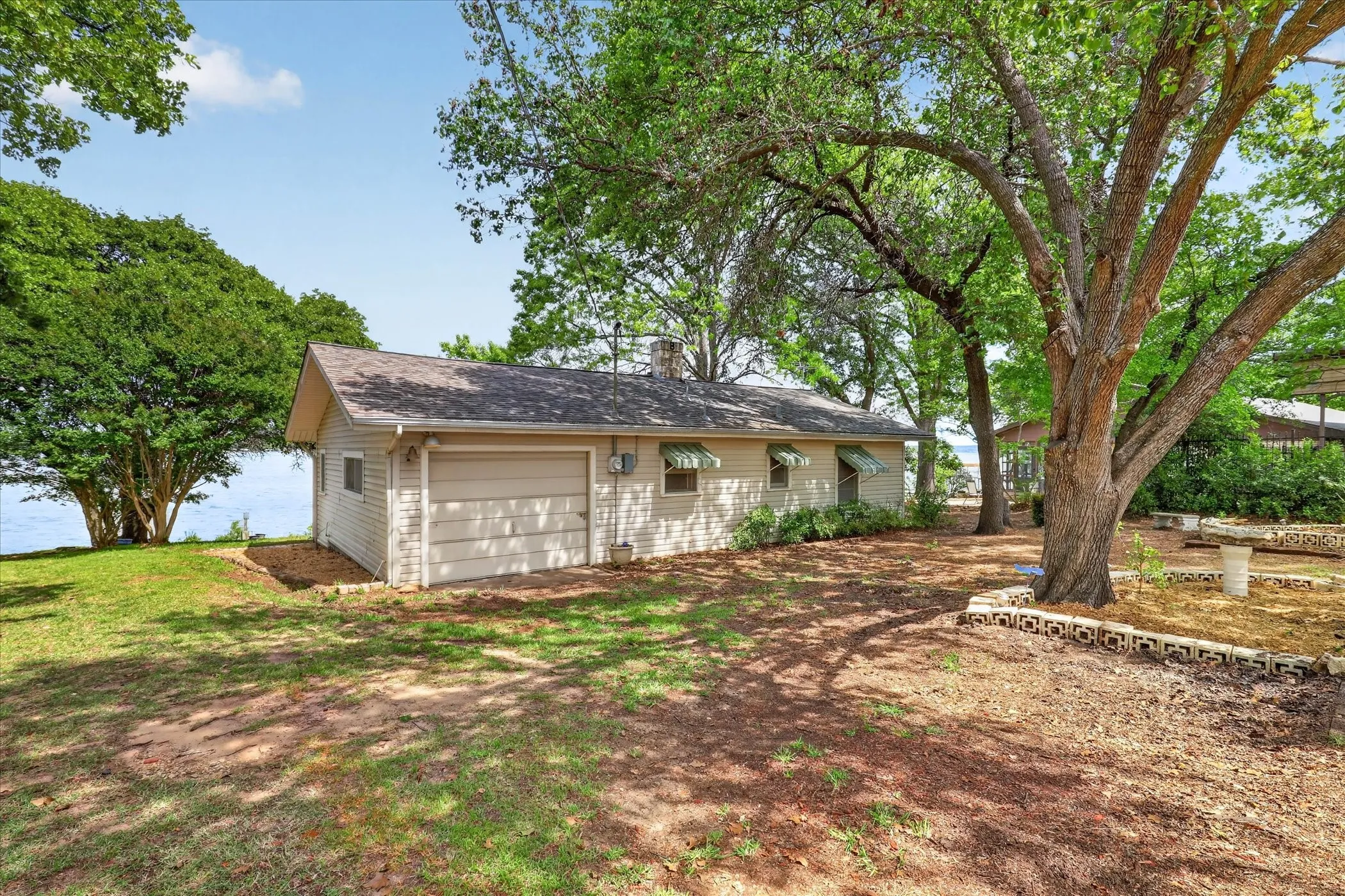 Back of house with a garage and mature trees
