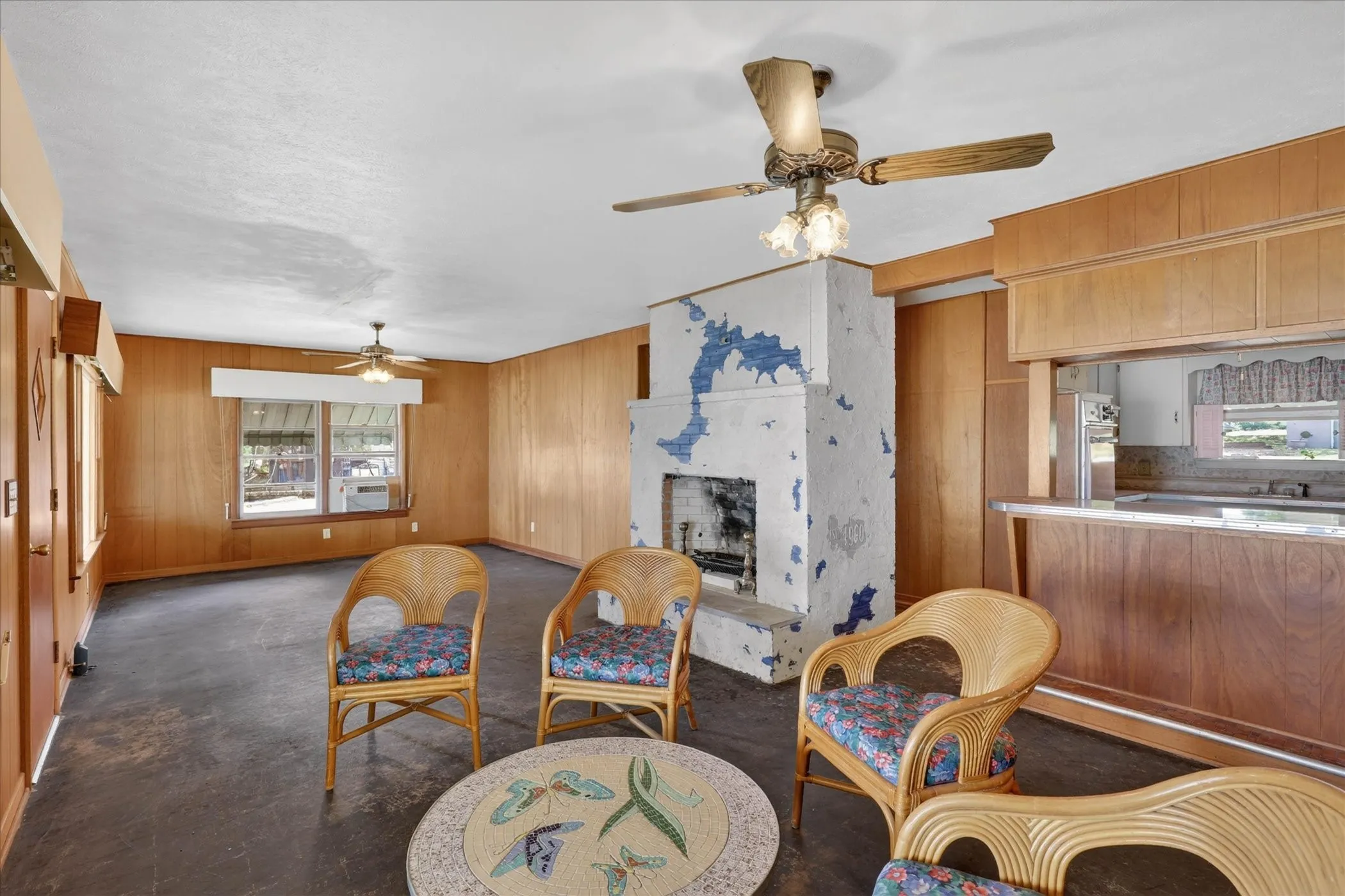 Open living room featuring ceiling fans, and a fireplace.