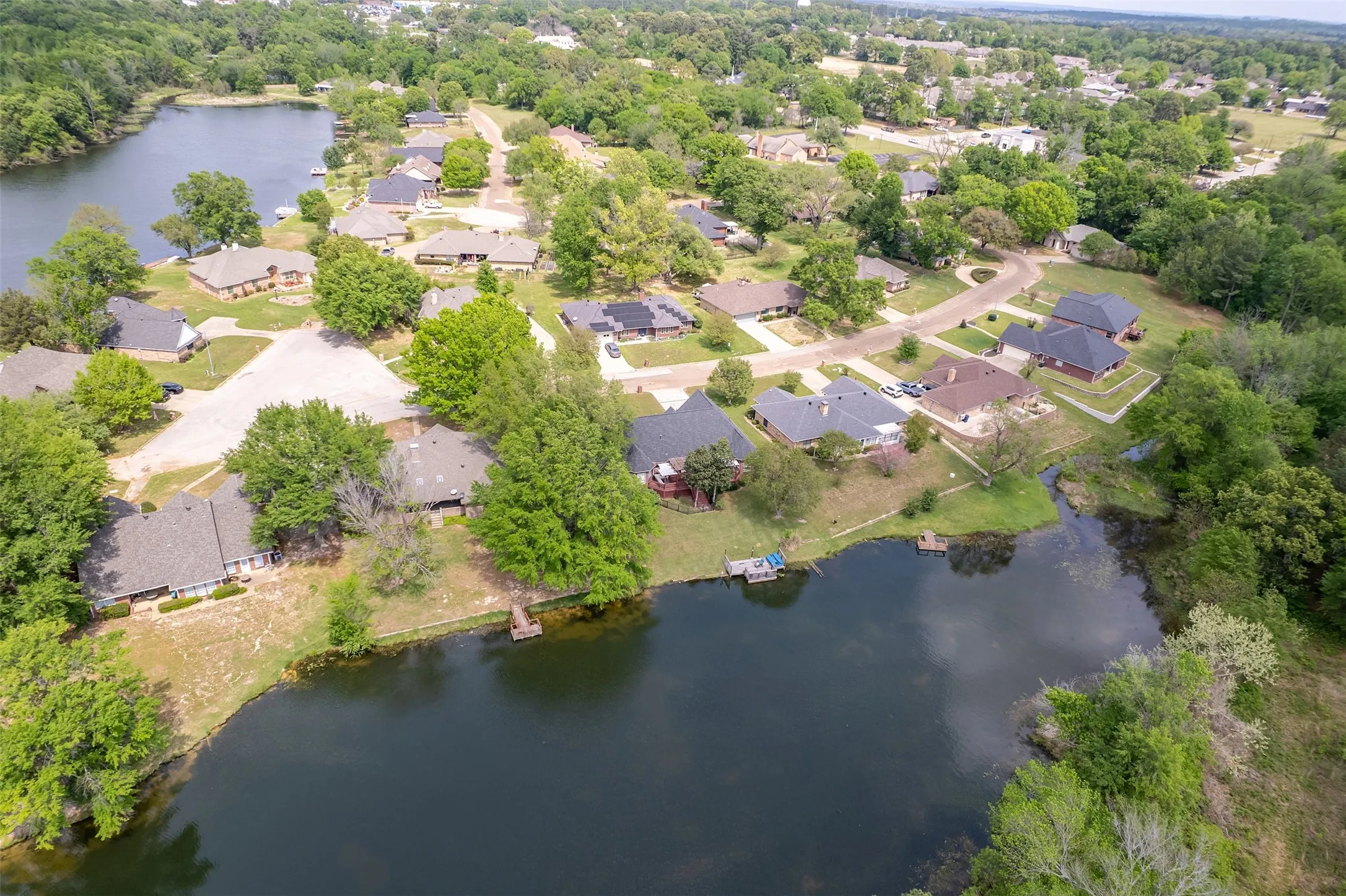 Aerial perspective of suburban area featuring a nearby body of water