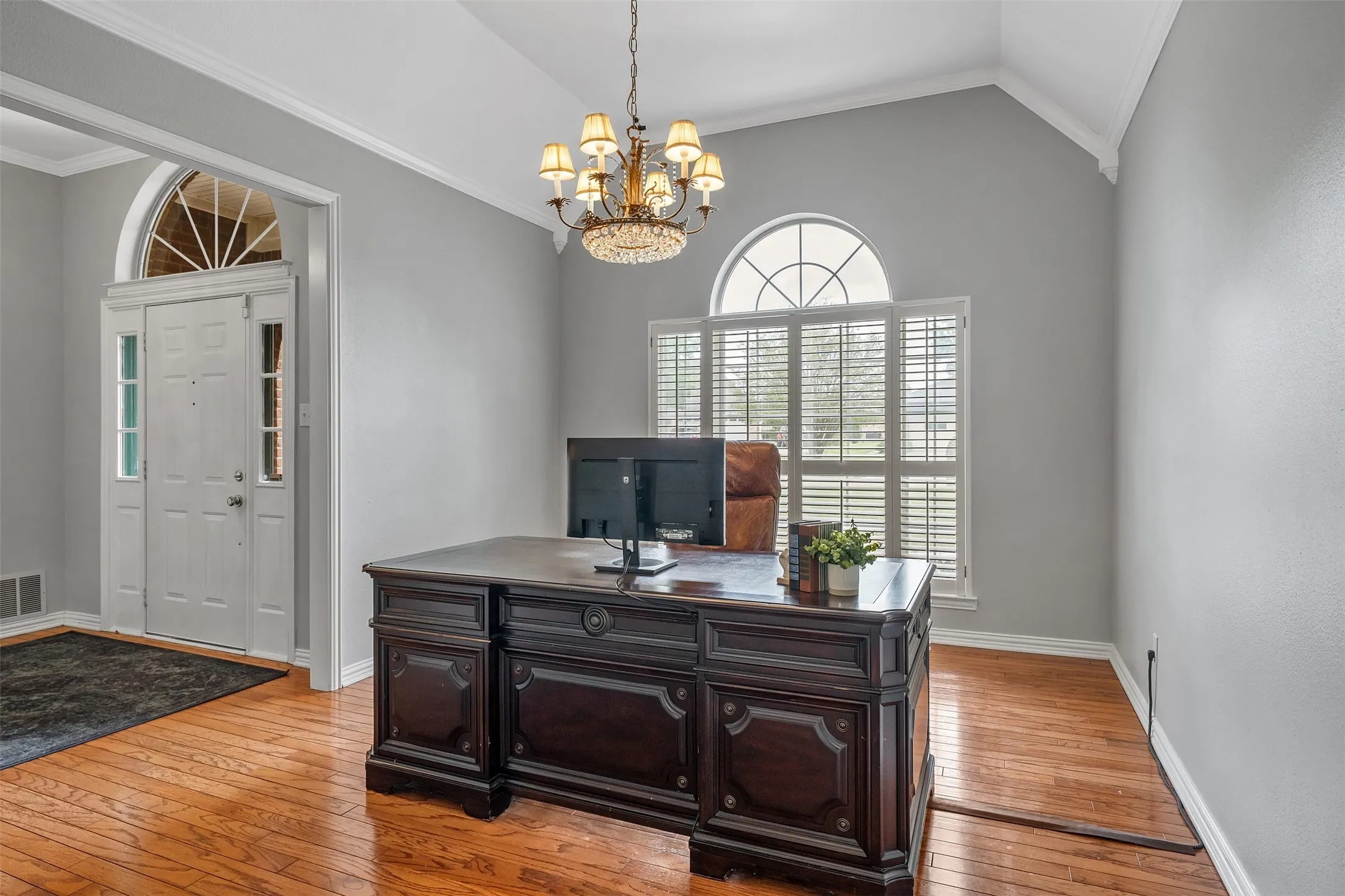 Home office featuring ornamental molding, hanging lights, light wood finished floors, and vaulted ceiling