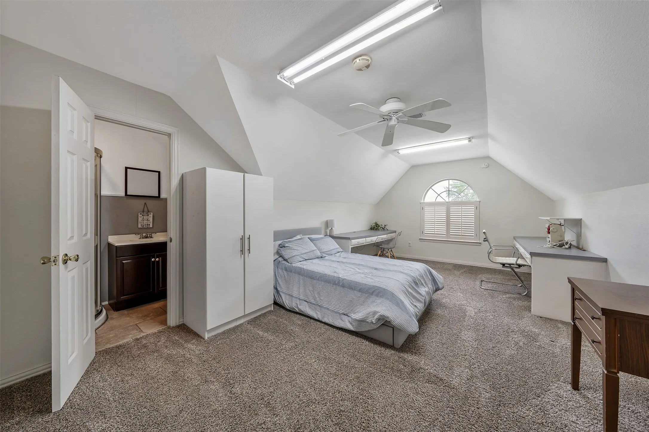 Bedroom featuring carpet flooring, ceiling fan, and connected bathroom