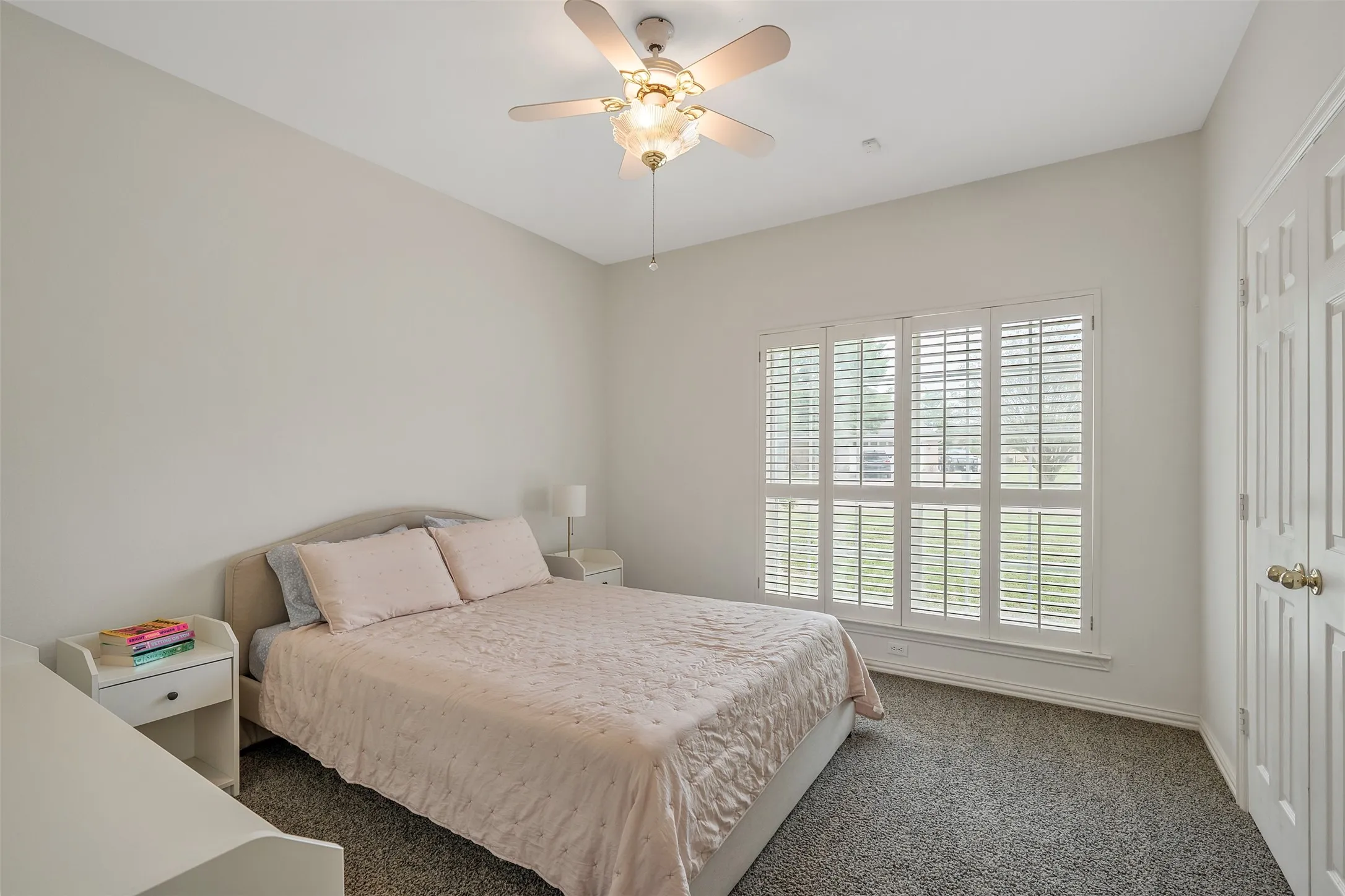 Bedroom with dark colored carpet and ceiling fan