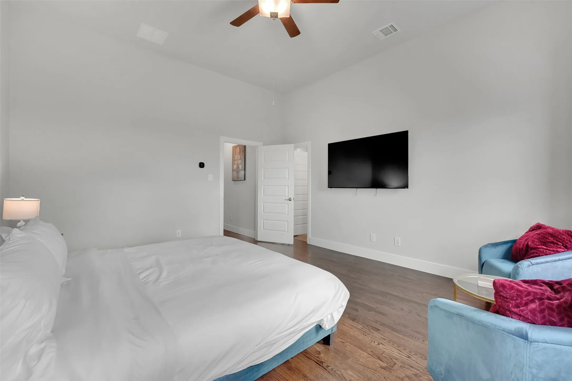 Bedroom featuring dark wood finished floors, ceiling fan, and a high ceiling
